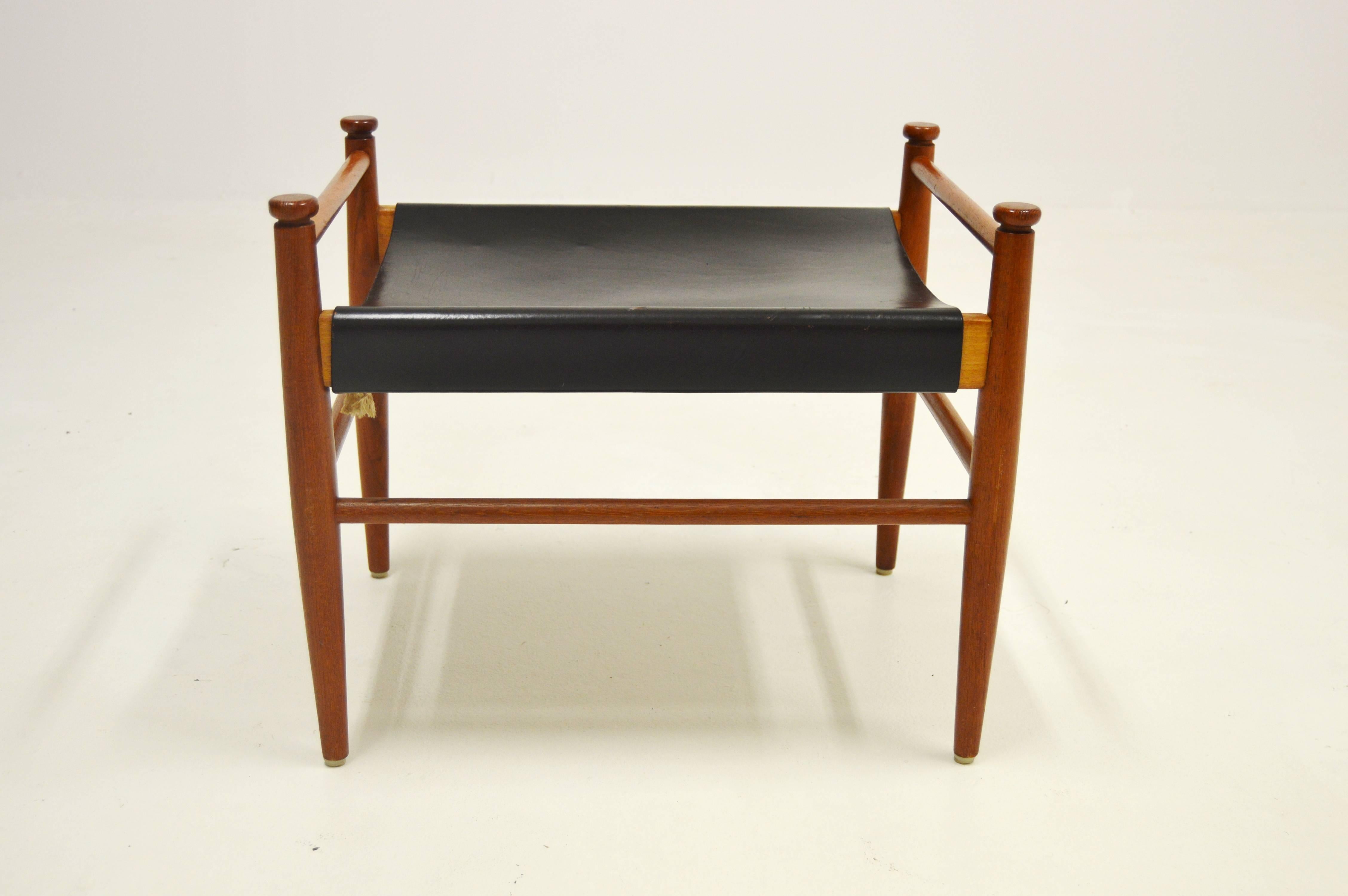 Sturdy footstool of better Scandinavian design, with elegant wooden details and leather seat, circa 1960.