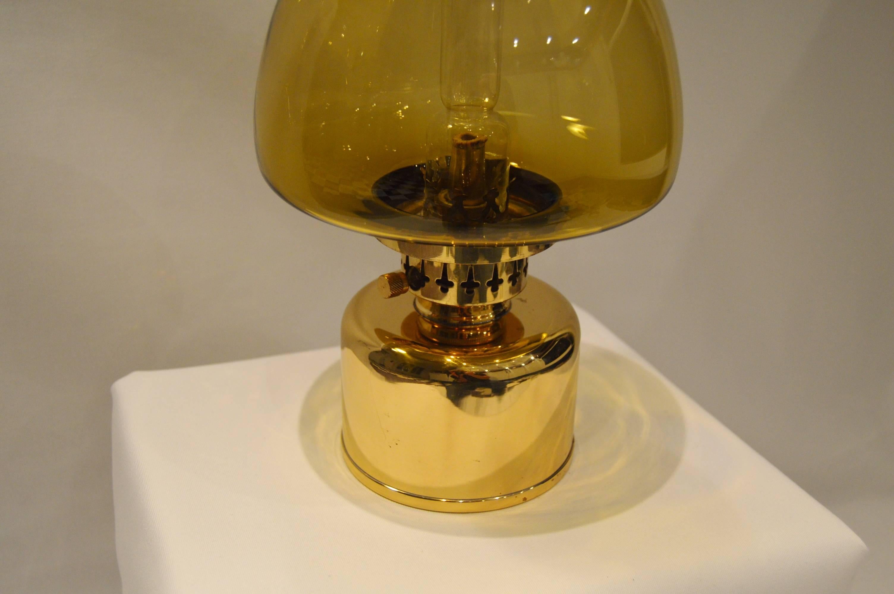 Elegant and rare kerosene lamp, even called oil lamp. Designed by Hans-Agne Jakobsson for his own company Hans-Agne Jakobsson AB in Markaryd, Sweden.

- Gold yellow glass and brass.
- Excellent vintage condition with nice patina on the brass.
-