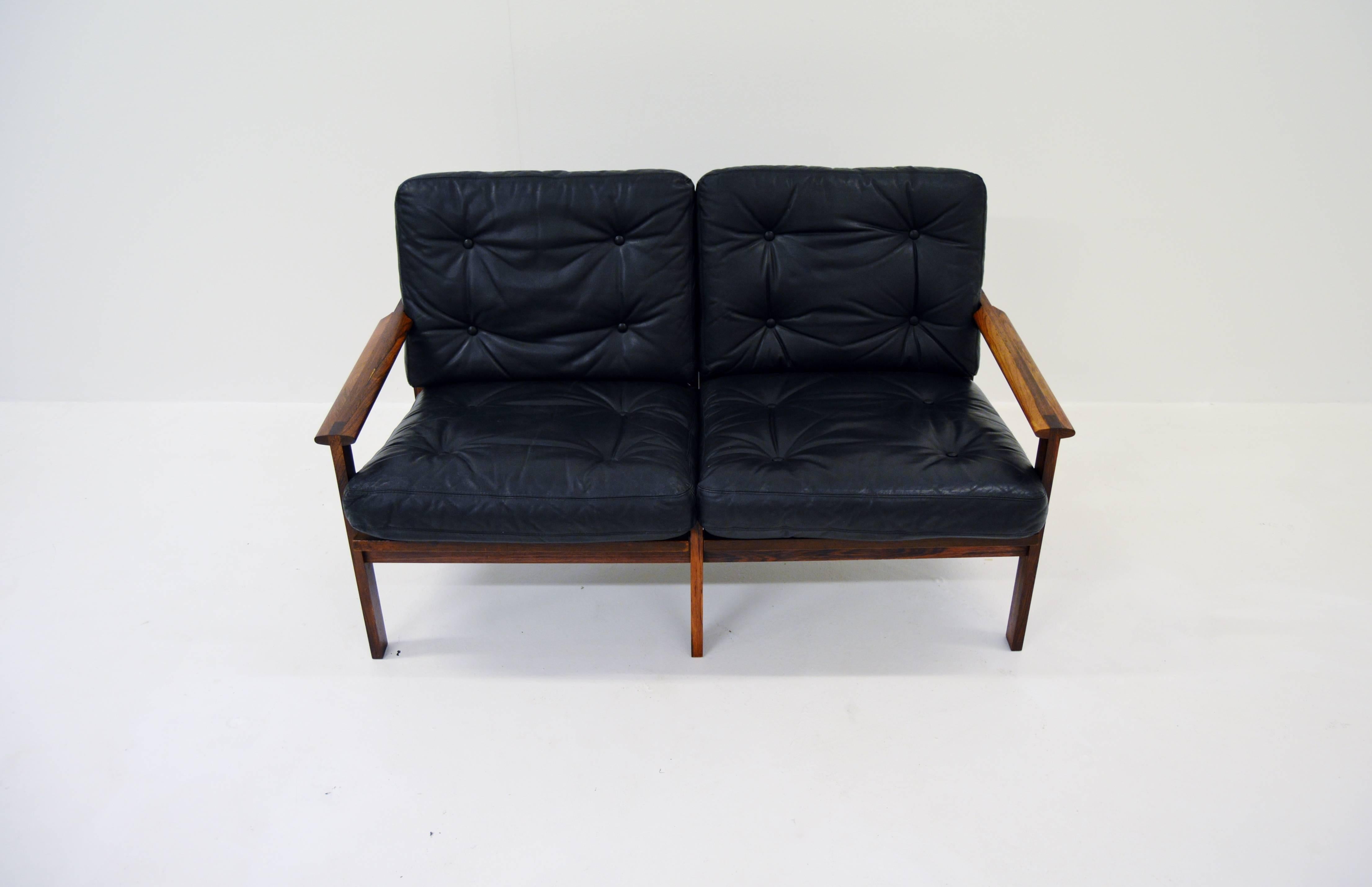 Two person sofa by Illum Wikkelsö with frame of rosewood and cushions of black leather. 

Produced by Niels Eilersen, Denmark during the 1960s.

 