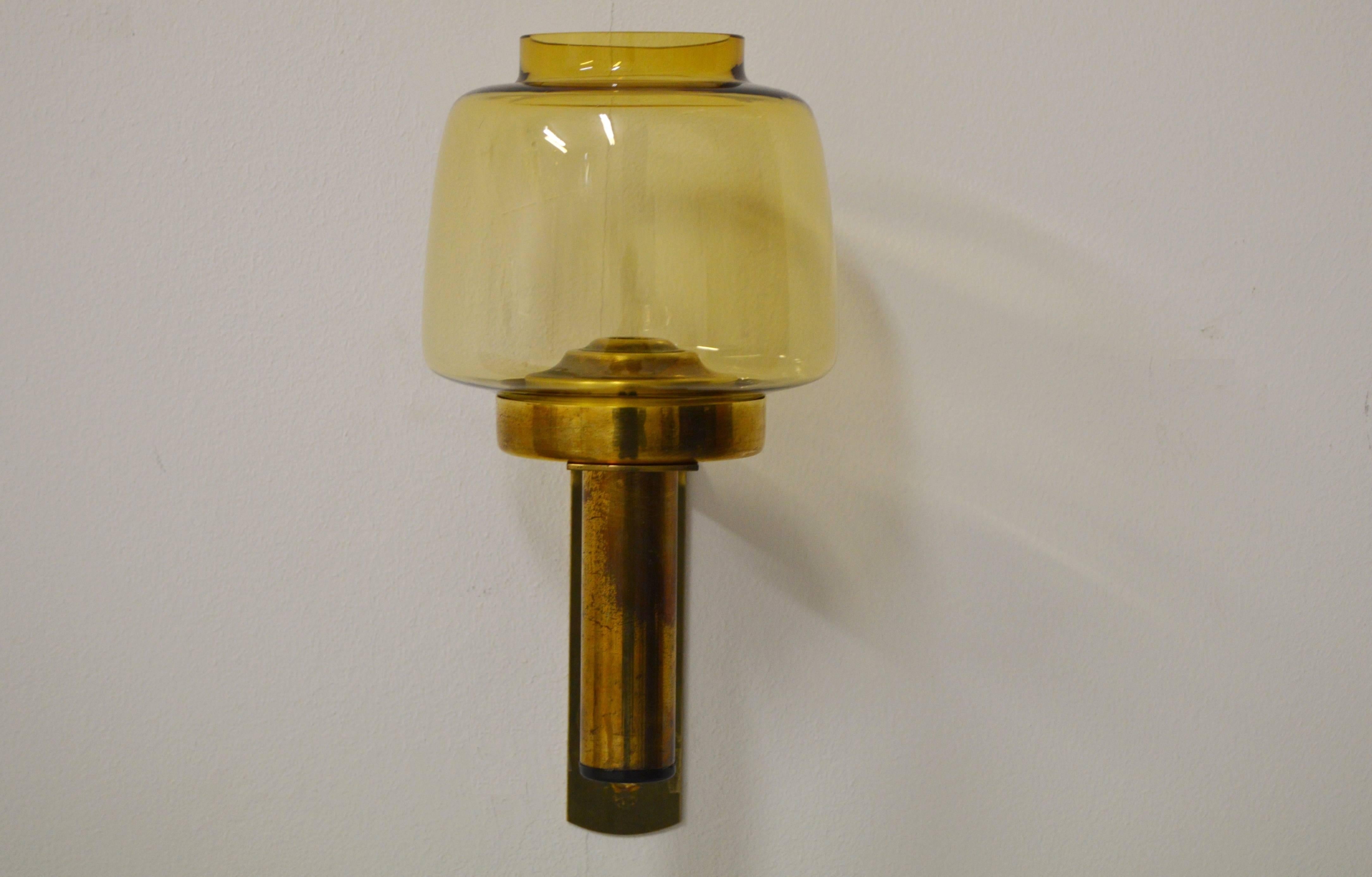 Decorative wall candlestick of brass with cup of handmade glass.
A spring ensures that the light is held in place and only the flame comes out.
Original producer label in bottom.
Design by Hans-Agne Jakobsson, Sweden.