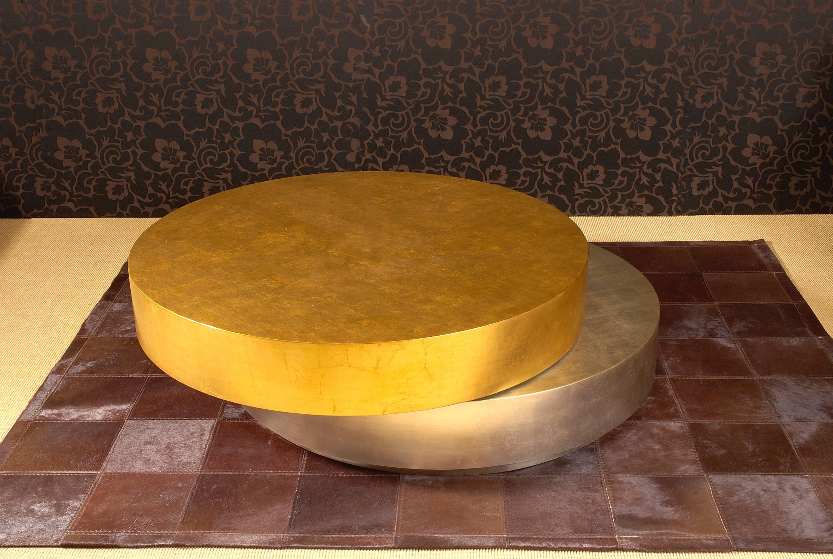 Coffee table composed of two same-sized circles, the upper circle can be rotated and make double exposed discs. The structure is in wood. 
The top circle finishing is in gold leaf and the below circle finishing is in silver leaf.
The open measure is