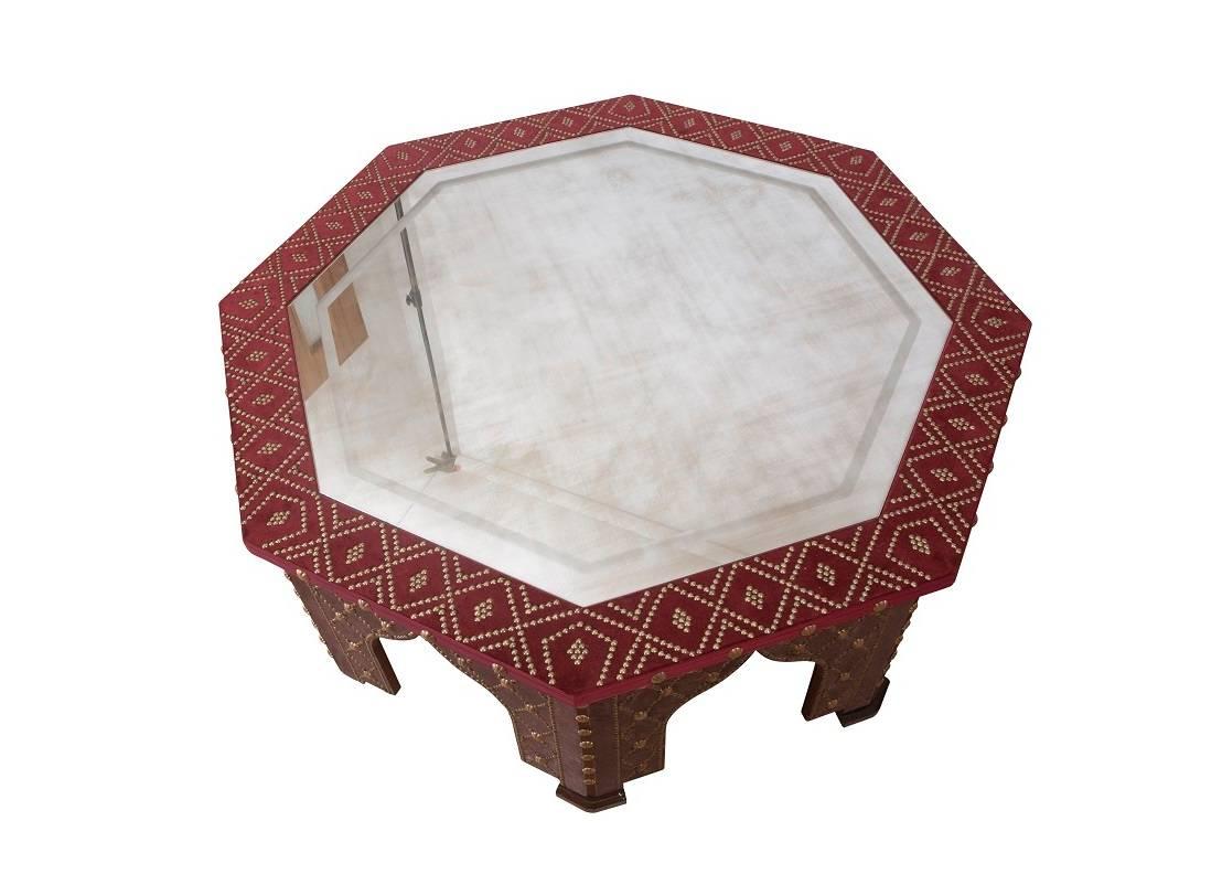 The Damascene coffee table, shown here in studded red velvet with antiqued mirror top, is part of the velvet furniture collection designed by Alidad Ltd and Thomas Messel and based on Baroque Neoclassical shapes as well as ancient Islamic designs.