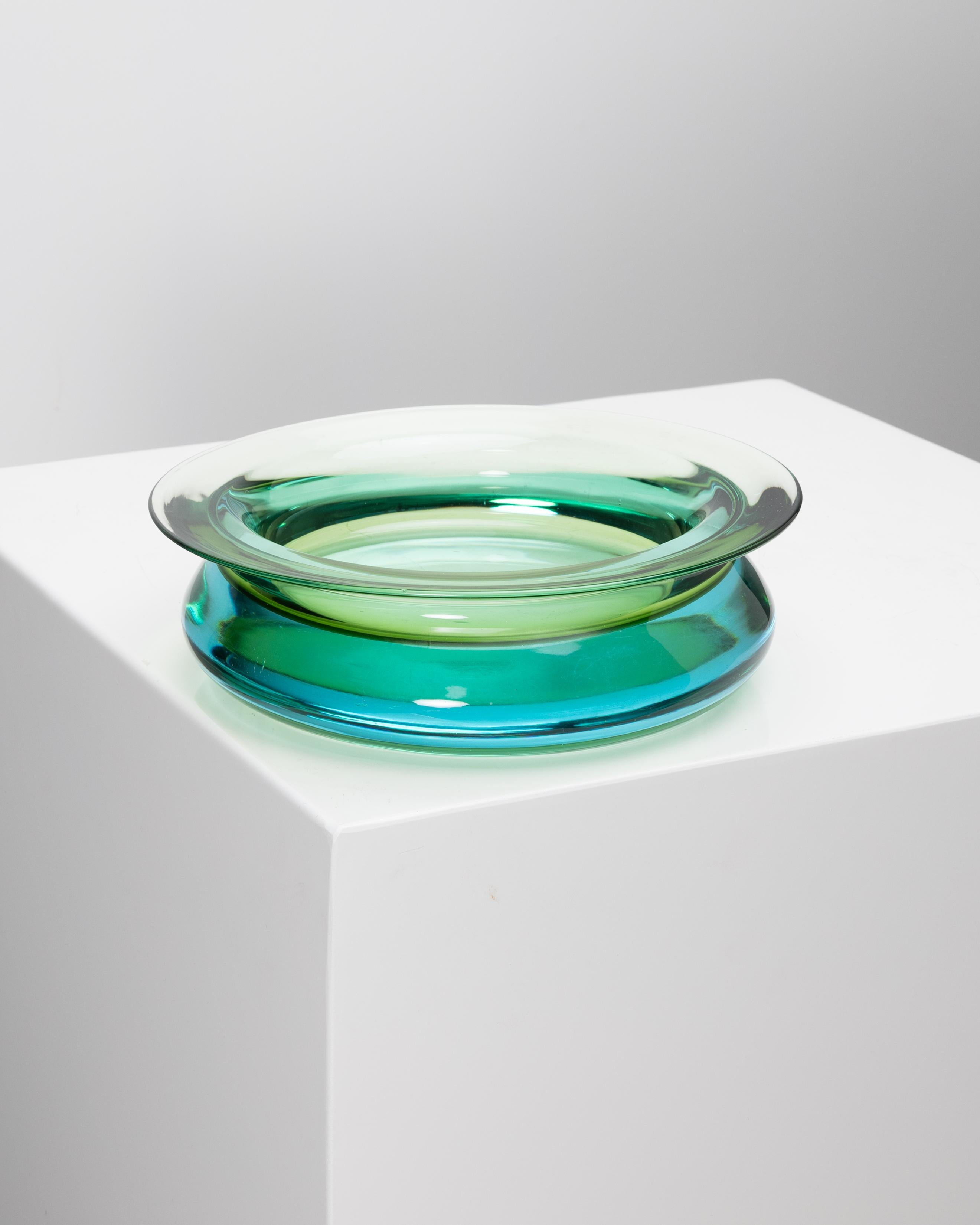 Vaso in vetro di Murano di Mario Pinzoni, Seguso Vetri d'Arte.
Vaso basso e largo con un profilo arrotondato e un bordo leggermente svasato.
Realizzato in vetro sommerso, il corpo verde oliva trasparente è immerso in una massa di vetro acquamarina