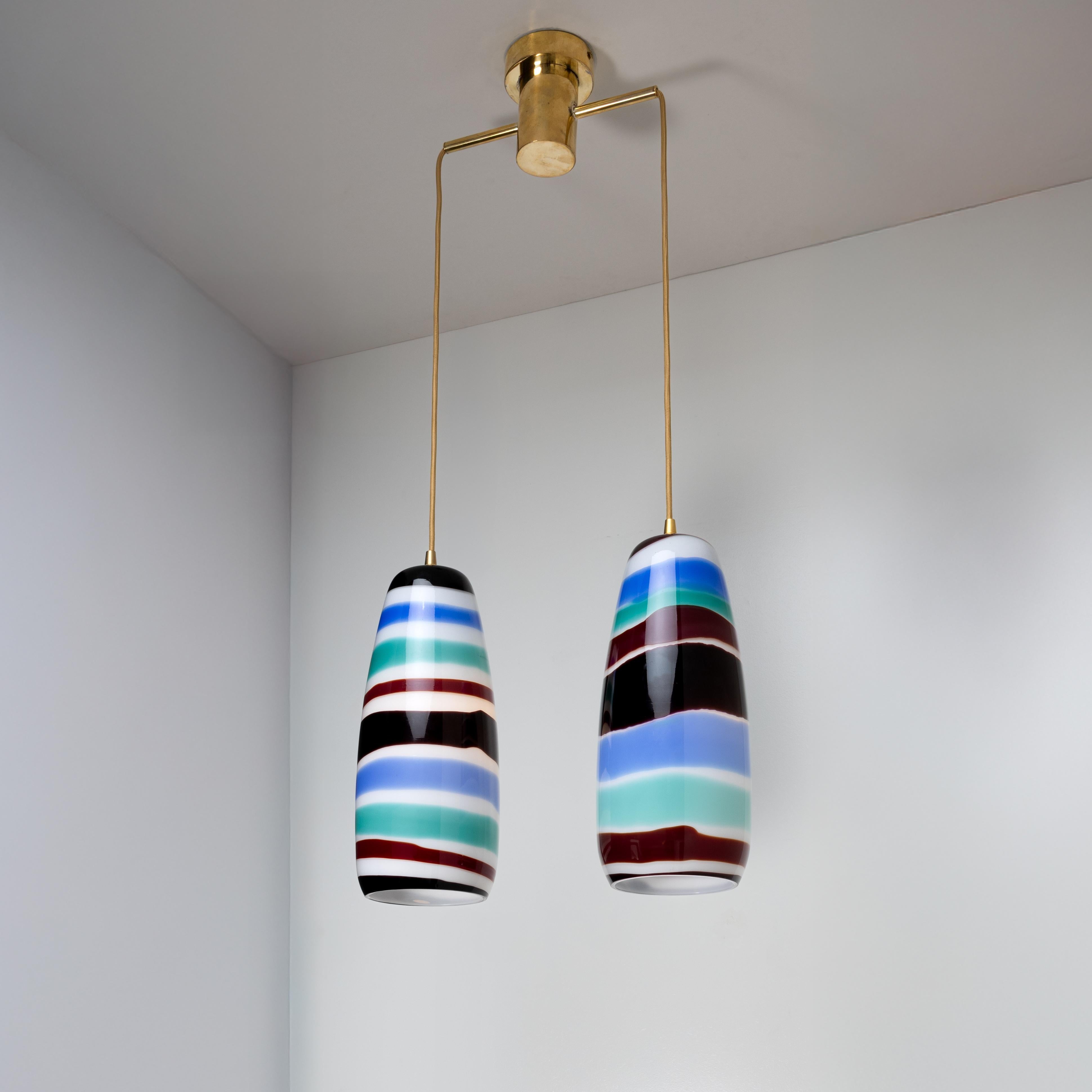Double ceiling light by Massimo Vignelli, Venini, Murano, Italy (founded in 1921).
Cigar-shaped in white glass decorated with multi-colored bands.
Referenced in the Venini archives under number 4035.
You should know : 
New electrification compliant