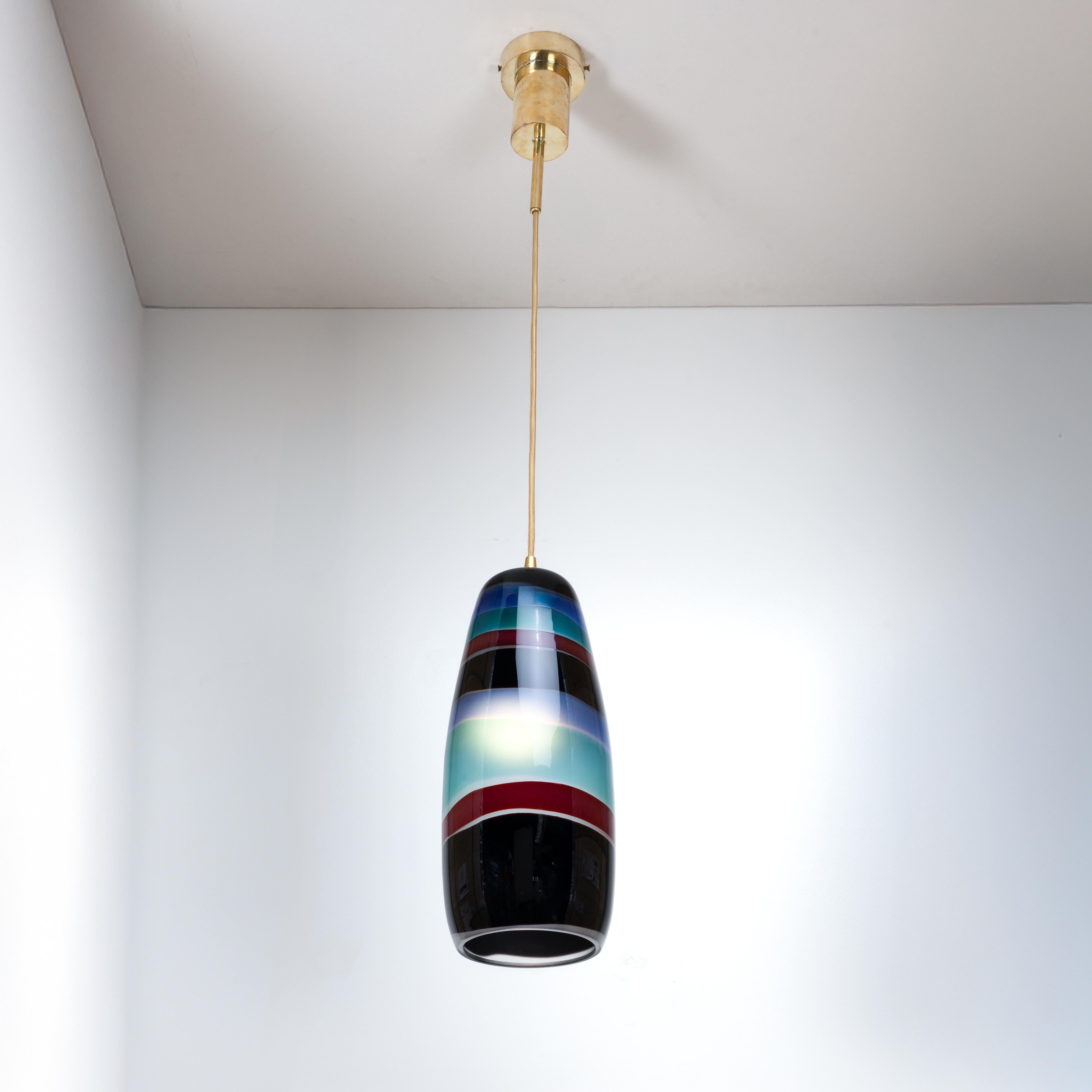 Single ceiling light by Massimo Vignelli, Venini, Murano, Italy (founded in 1921).
Cigar-shaped in clear sandblasted glass decorated with multi-colored bands.
Referenced in the Venini archives under number 4035.
You should know : 
New
