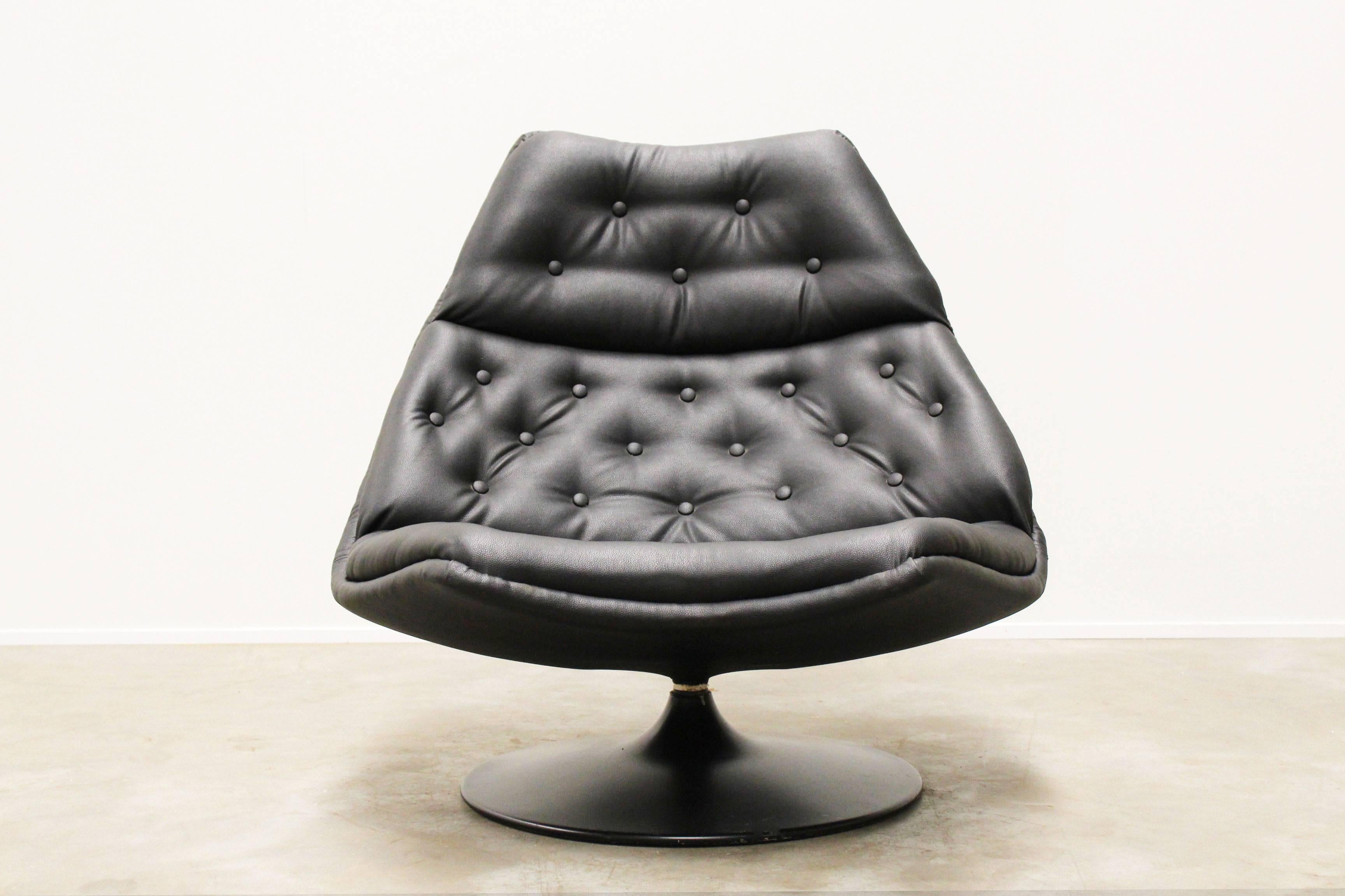 Wonderful swivel lounge chair by Geoffrey Harcourt for Artifort, 1960. The chair has a black metal trumpet base with black faux leather upholstery. A Very comfortable lounge chair. Chair is in very good shape only one button on the seat cushion is