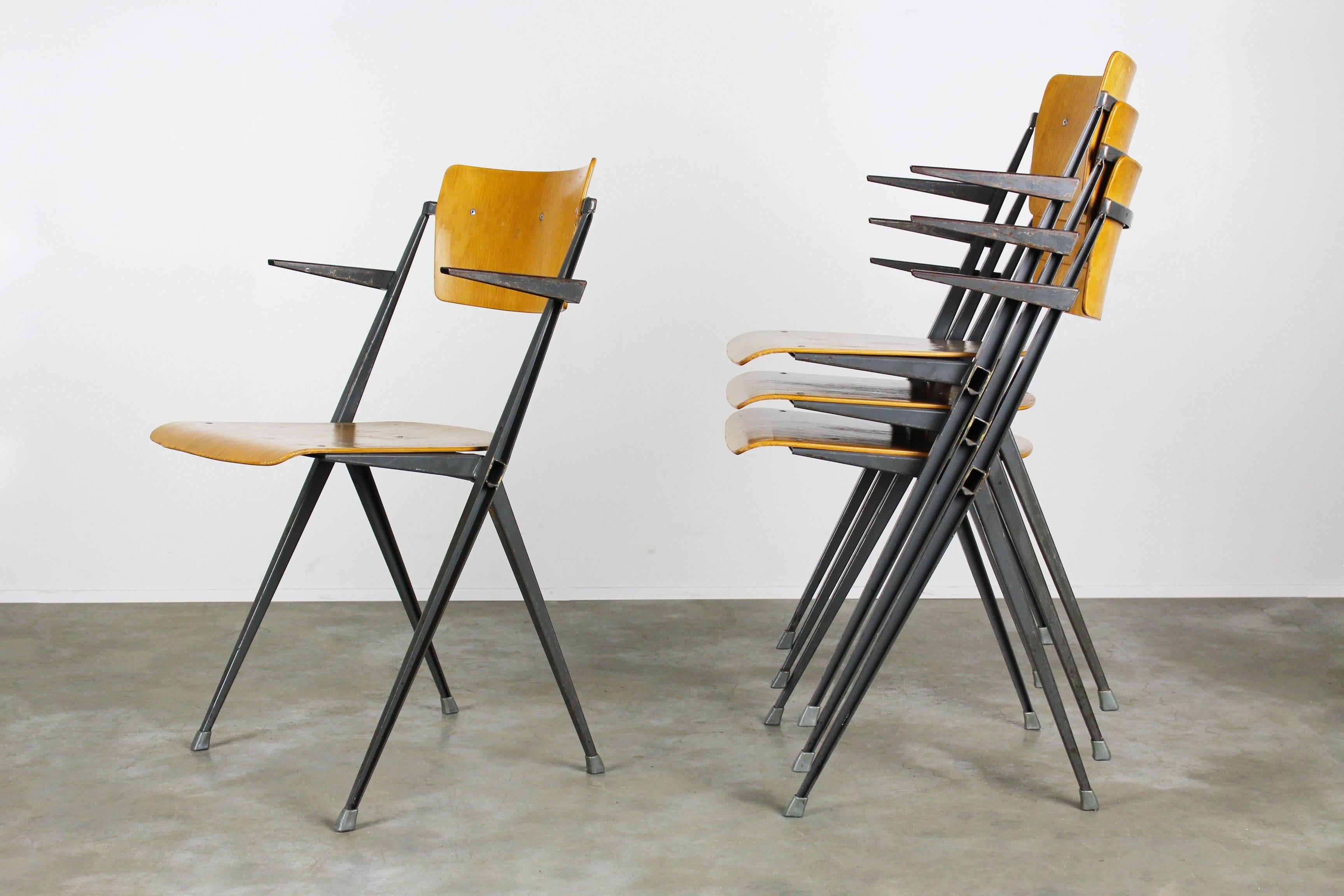 Set of four pyramid chairs with armrests designed by Dutch designer Wim Rietveld for Ahrend de Cirkel in 1963. Very difficult to find set. The chairs have a wonderful patina especially the armrests. The design of these chairs always draws your