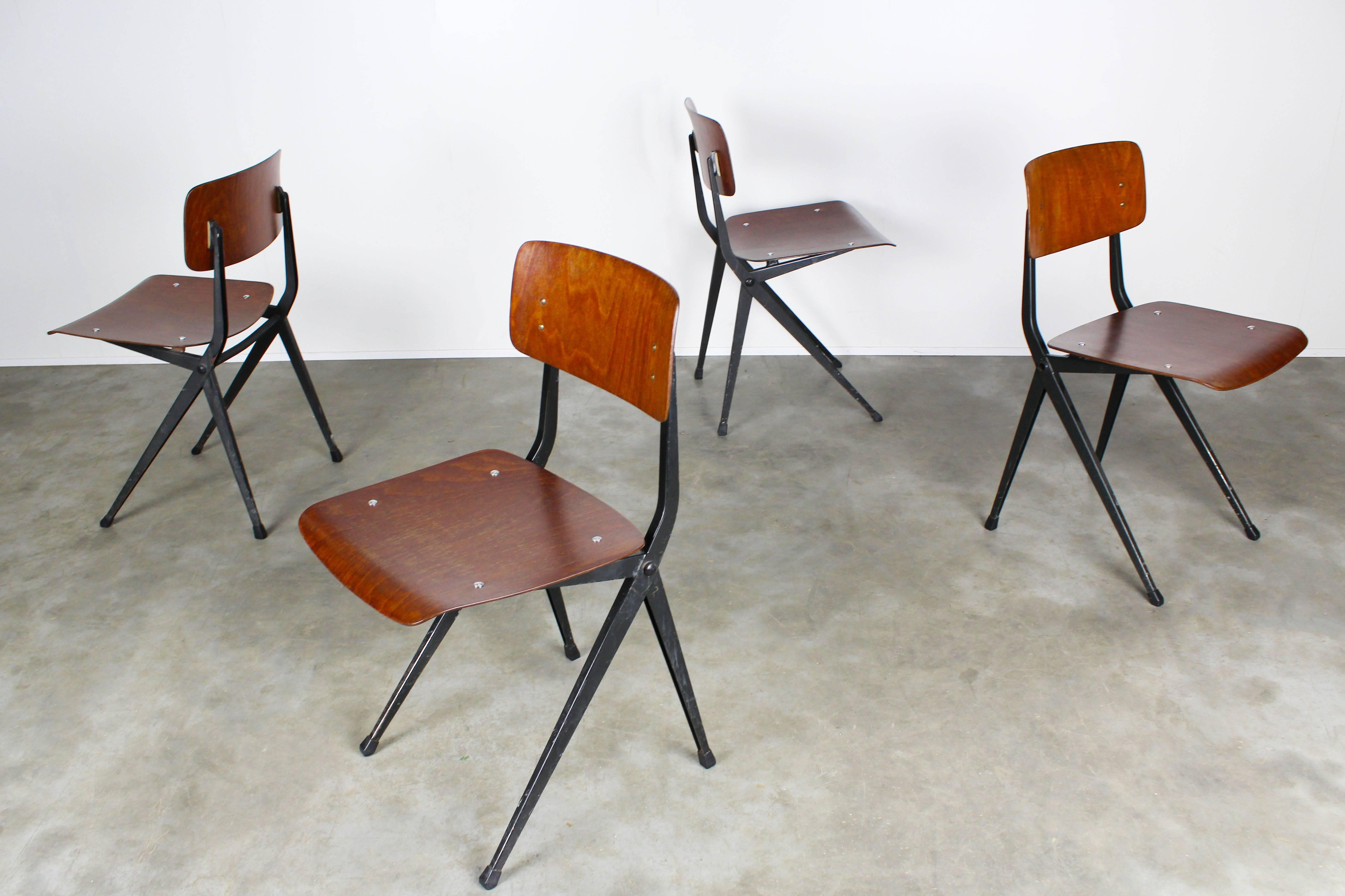 Set of eight Dutch Industrial Design dining chairs by Marko. The steel frame has the elegant compass shape distinctive to Friso Kramer & Gerrit Rietveld. Black frame with warm plywood seat and backrest. Traces of age and use on frame and wood please