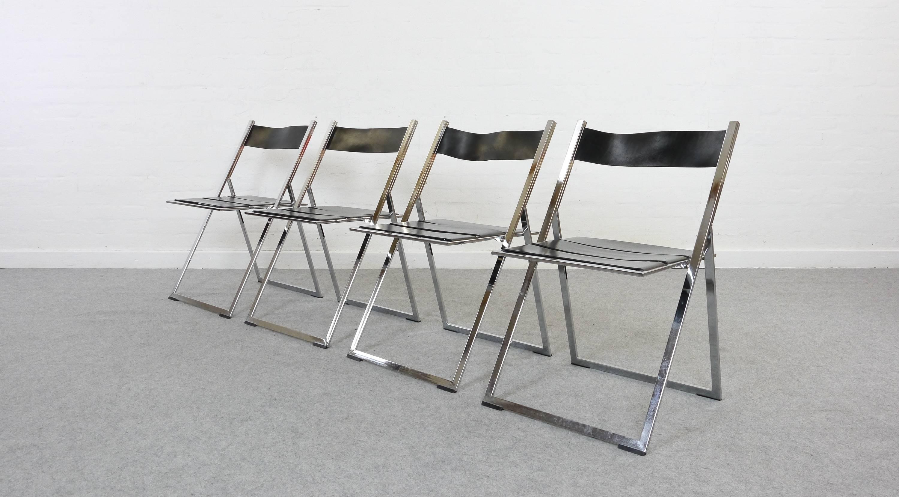 Set of four chromed steel and black leather dining chairs/folding chairs. Probably the most stylish folding-chair ever produced. When folded, the chairs have only 2 cm in depth. Accurate to store away! Designed by Lübke/Interlübke, Germany, circa