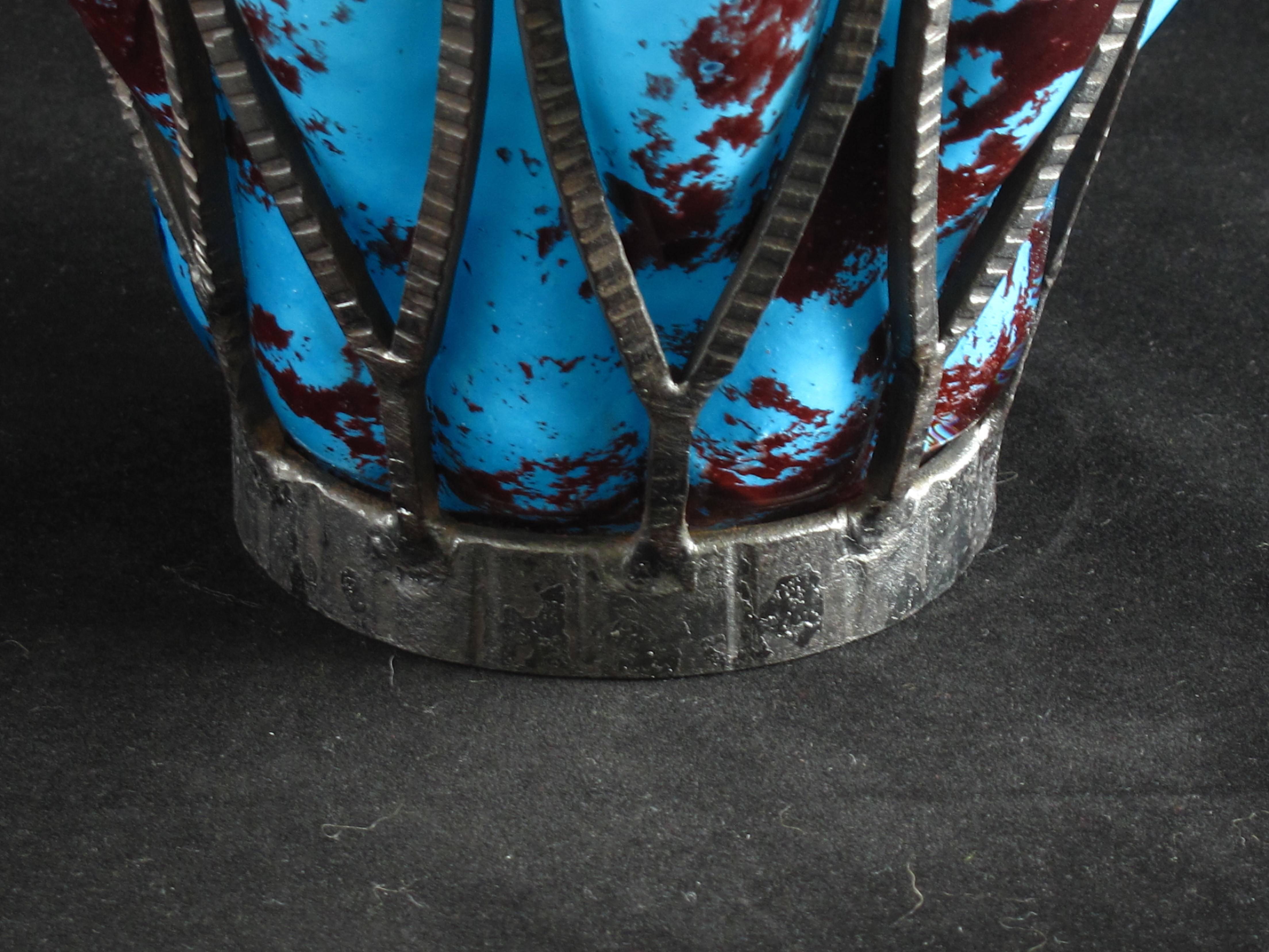 Un grand vase Art Déco en verre tacheté et emboîté soufflé dans une armature en fer forgé. Signature gravée sur la base Daum Nancy et Louis Majorelle, français, vers 1920. Une couleur étonnante.

En 1878, Jean Daum (1825-1885) rachète la verrerie