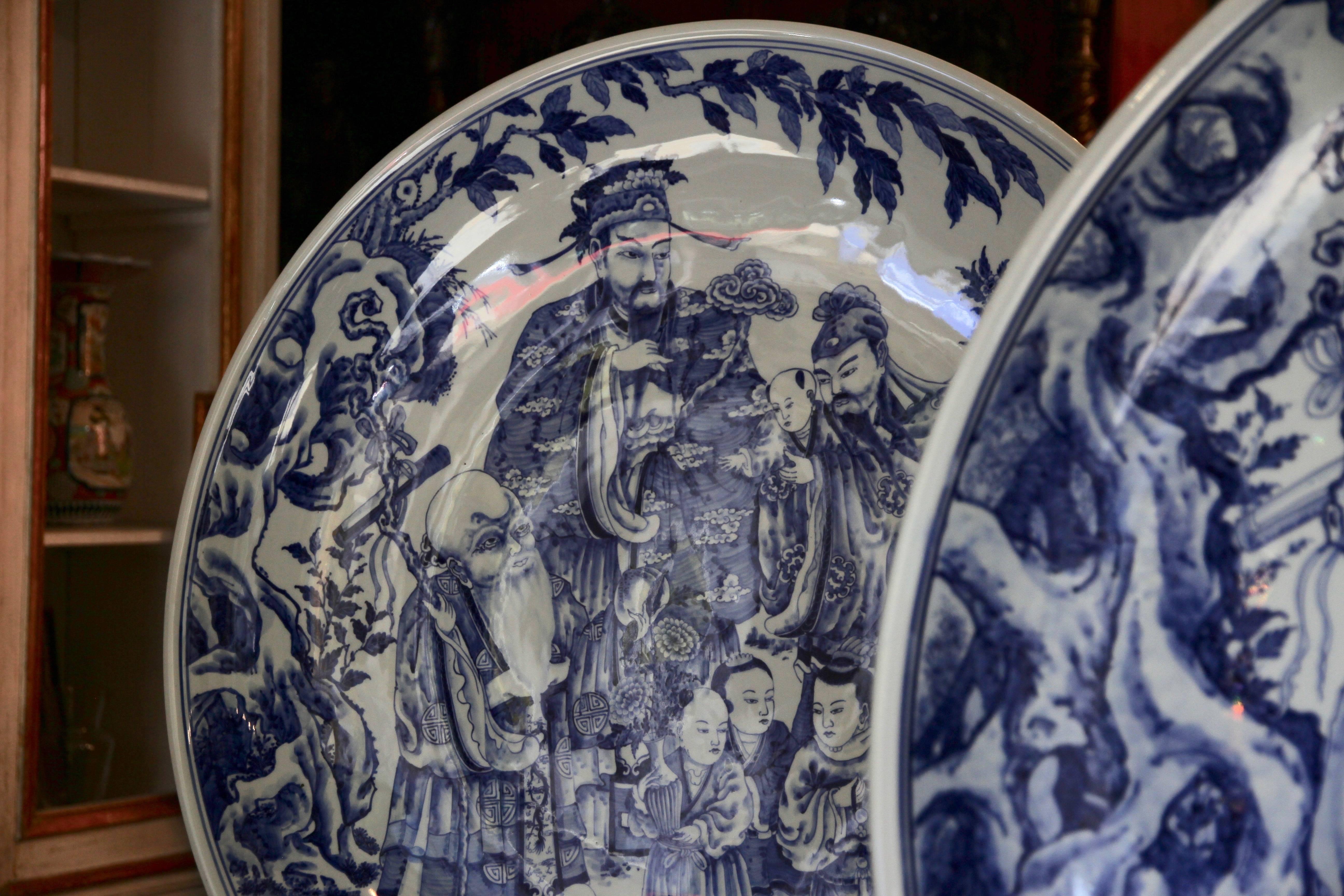 Pair of blue and white ceramic plates figuring Fú, Lù and Shòu, three gods representing three qualities of Prosperity (Fu), Status (Lu), and Longevity (Shou) in Chinese religion.

Fu wears, in general, a scholar or mandarin dress. Lu is holding a