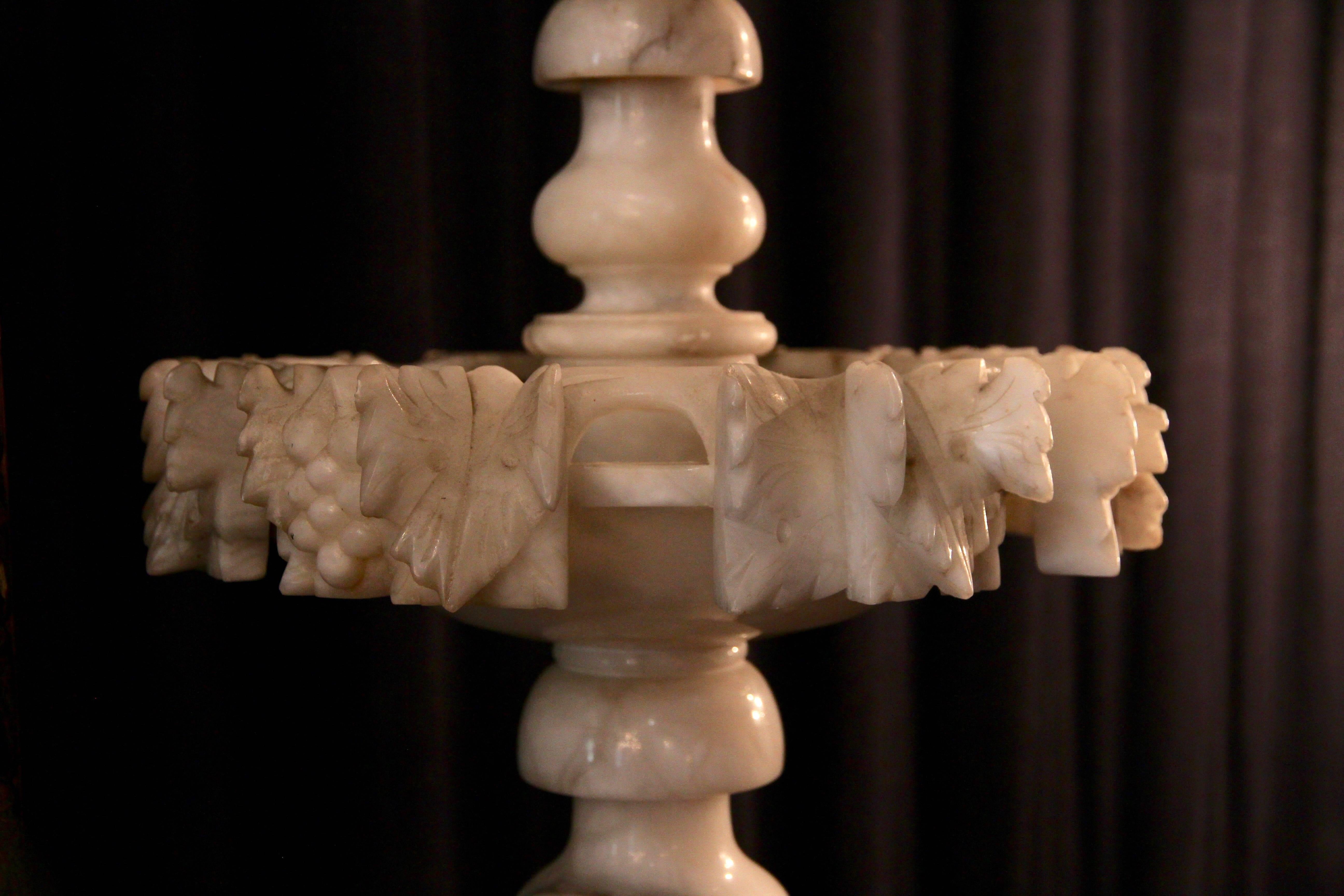 Delicate alabaster centrepiece with three sculpted plates and a baluster shaped foot. The top is decorated with sculpted foliage’s.