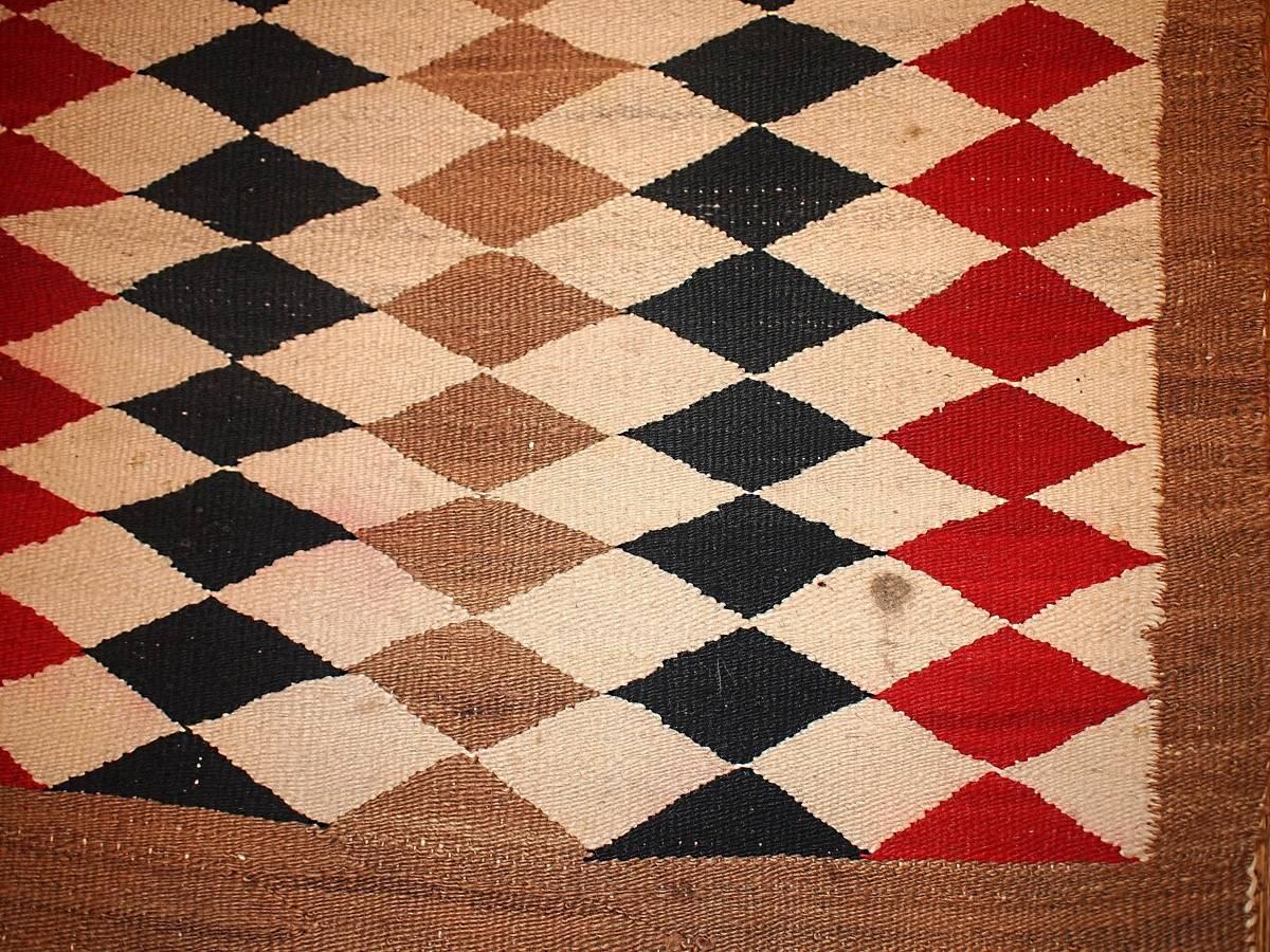 American-Indian Navajo rug with geometric design. In red, brown, beige and black colors. Symmetric design makes it look very modern in our days.
   
