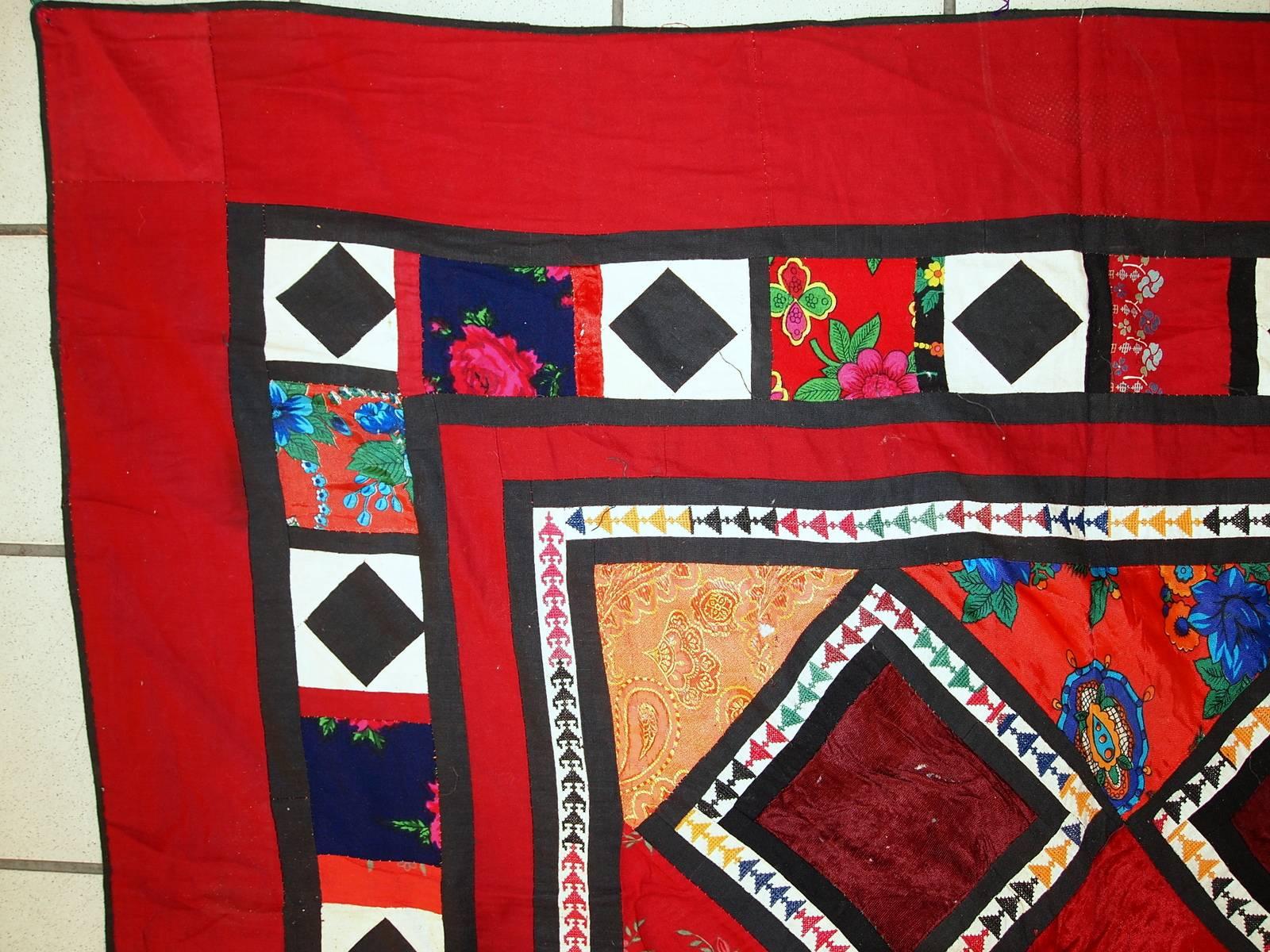 Handmade vintage Uzbek patchwork Suzani rug in original condition. This Suzani is in colourful shades. On the cotton red base there are velour diamond shaped patches along the centre of the rug. Also smaller squarish patches along the border. The