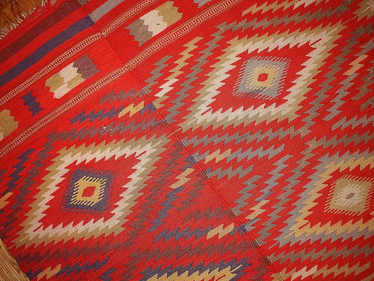 Handmade antique Moroccan Kilim in bright red color with colorful diamonds all-over it. Classic tribal design makes this piece look very elegant. It might make your room look authentic and trendy.