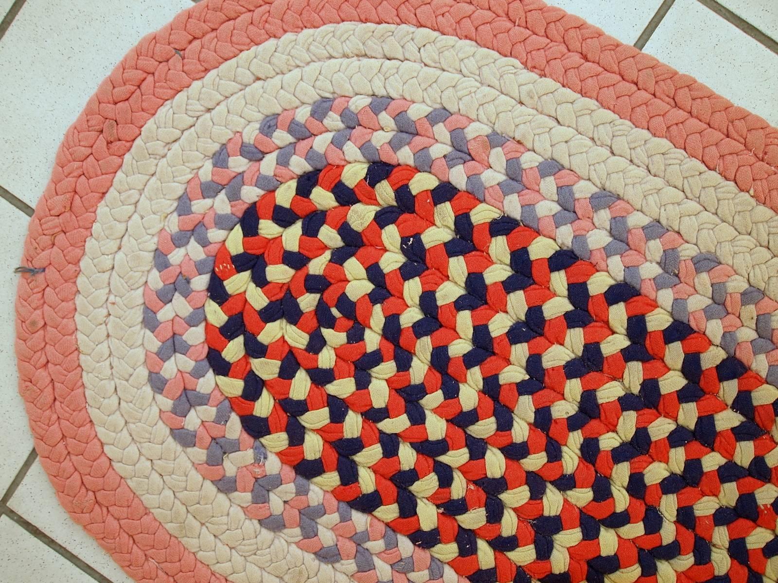 Antique handmade American braided rug in original condition. Very Classic American rug made out of cotton stripes in beige, red and rose shades.