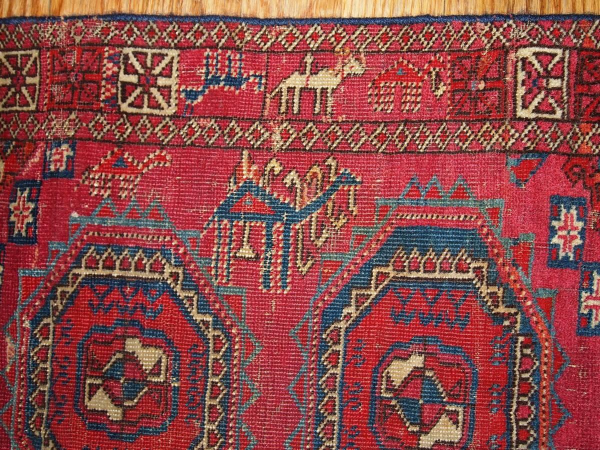 Mid-19th century Turkoman Saryk rug. Classic design in unusual scarlet color. Little details and silhouettes of people and animals represented in azure, beige and burgundy colors. Very fine rug.

  