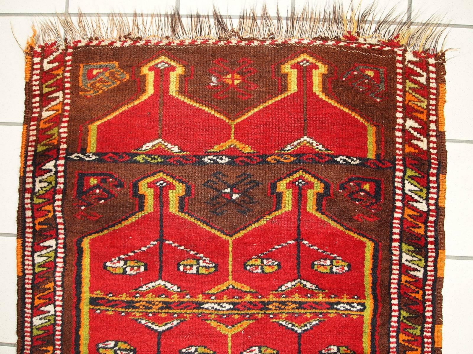 Antique Turkish Yastik rug in original condition. Very unusual shape and beautiful design on the burgundy field. The repeating itself large red tribal ornaments as medallions covering the field. The border is also in national design full of