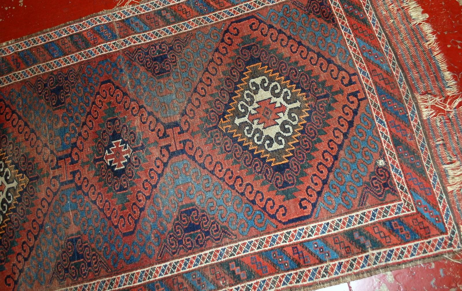 Handmade antique collectible Afghan Baluch rug in original condition. The rug has very beautiful blue background with detailed design on it and three large diamond shaped medallions in the centre. Very nice colourful border is around. The rug is in