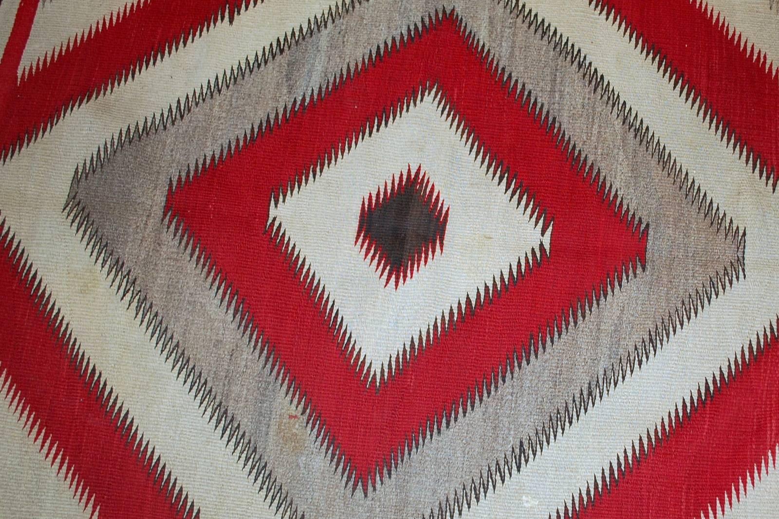 Antique handwoven American-Indian Navajo rug in original great condition. The rug is in three colors with geometric zooming diamond shaped medallion in red, white and gray shades. Very symmetric modern look. Beautiful piece will go very well with