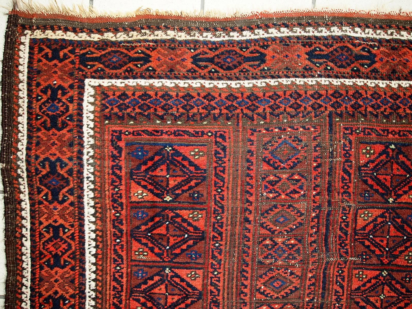 Antique handmade Afghan Baluch rug. This Afghan rug was made in combination of red, burgundy, white and blue colors. Beautiful tribal design with geometric accent. The condition is fair for the age, has some age wear.