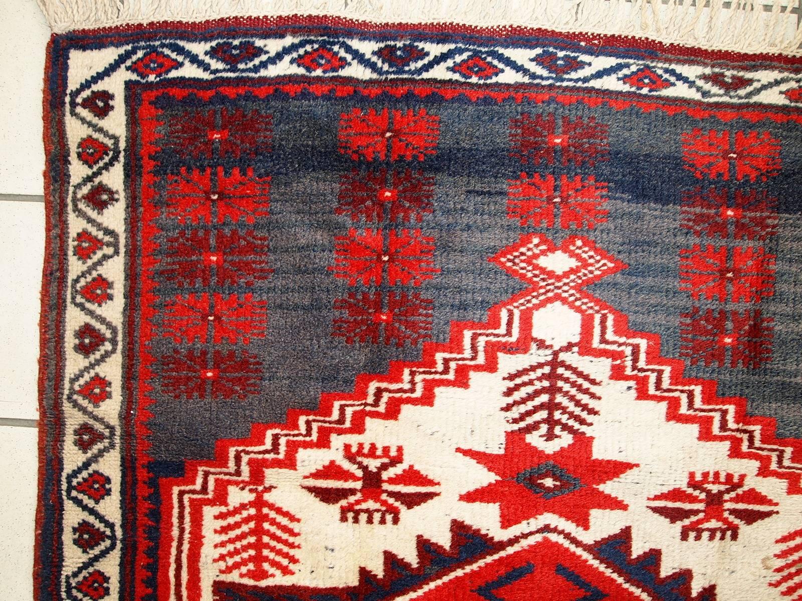 Antiker türkischer anatolischer Teppich im Originalzustand. Der Teppich hat ein traditionelles anatolisches Design mit einem großen rautenförmigen Medaillon in der Mitte in weißer Farbe. Hintergrundfarbe aufgeteilt in zwei (abrash) marineblaue und