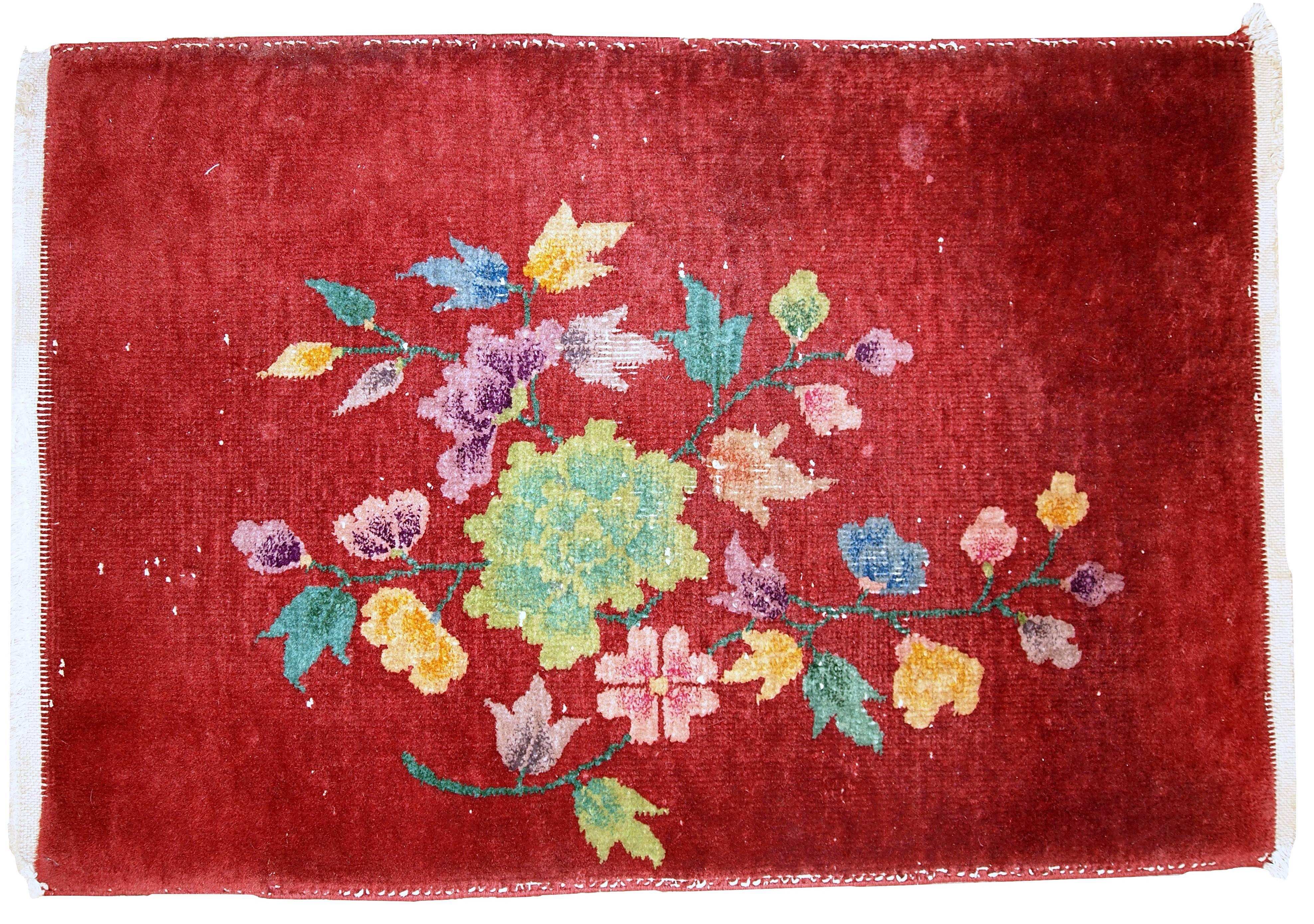 Antique Art Deco Chinese rug in original condition. The rug is in bright orange color. Decorative floral design in different shades or yellow, green and purple. The condition is original, has some low pile.
