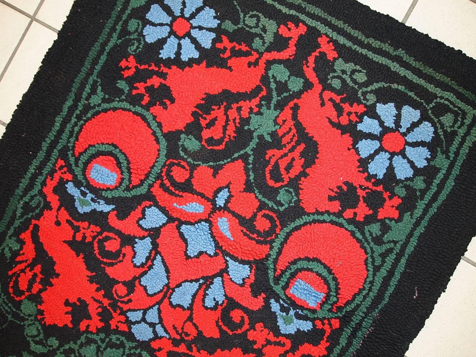 Handmade antique American hooked rug in original condition. The rug made in black shade for the background with bright red lions on it. The details are in green and sky blue shades. The rug is very thick and heavy made in high quality.