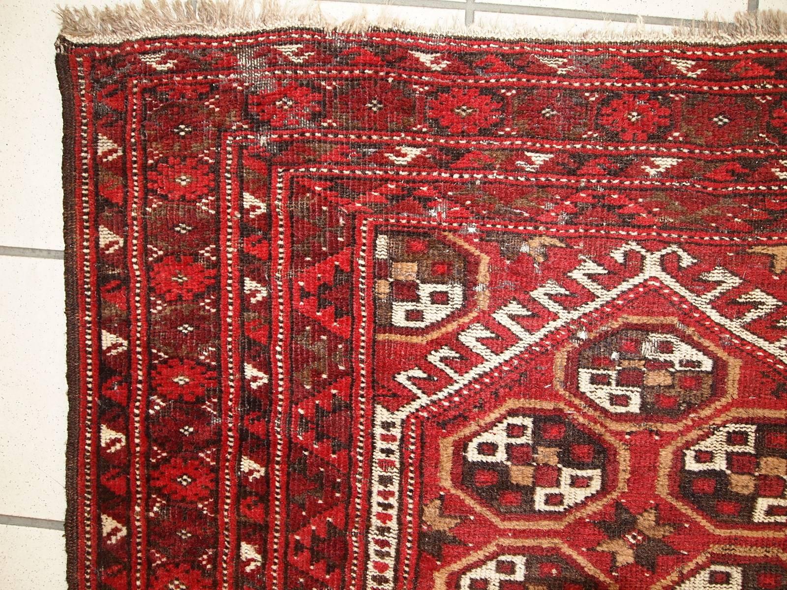 Antique Afghan Adraskand rug in original condition. The rug is in traditional colors of red, white and brown shade. The rug is prayer. Condition is original, has some moth damages. The rug is quite thin and light.