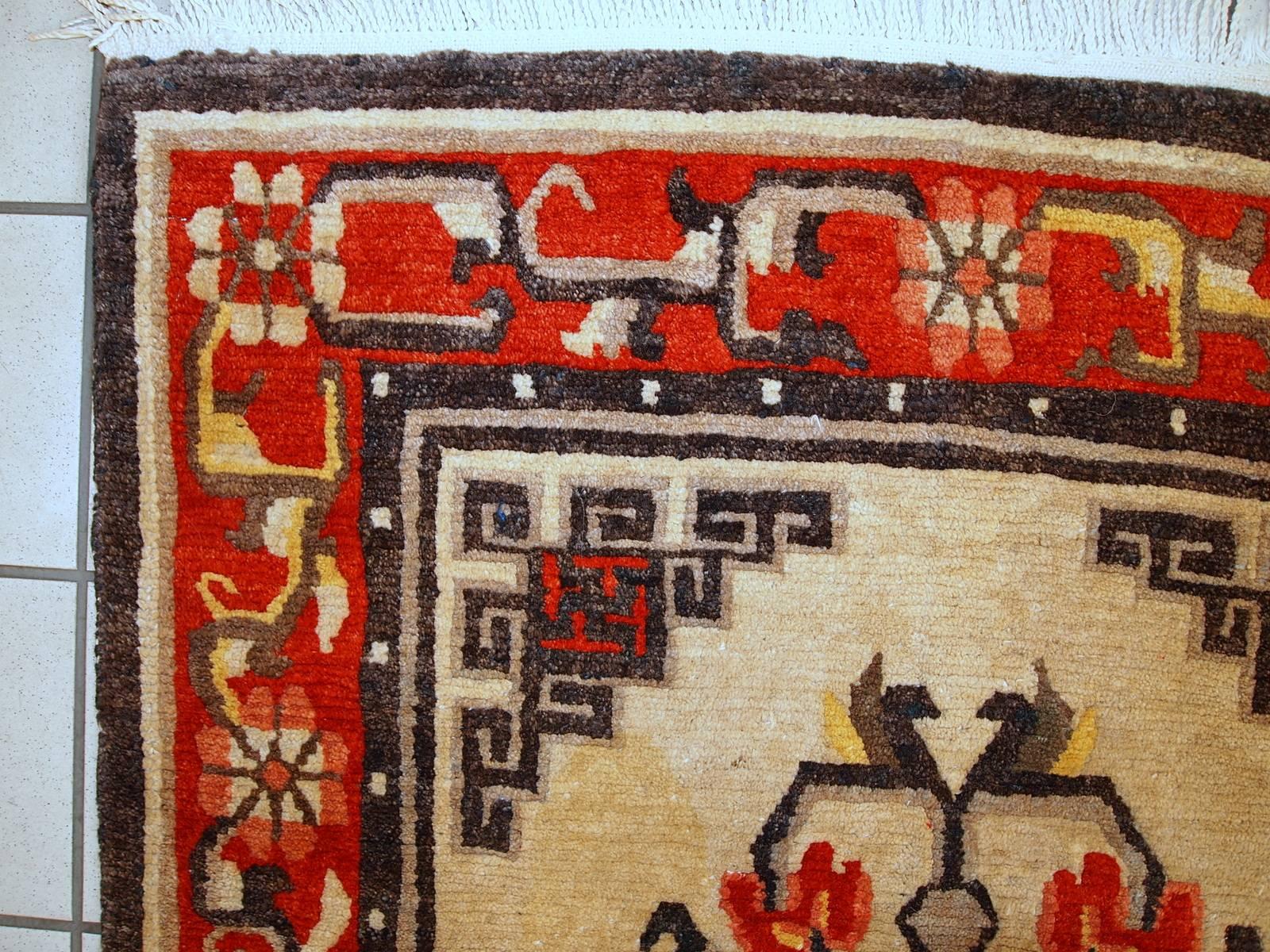 Beautiful vintage Mongolian rug in original condition. The rug was made in beige shade with tribal design in the center and bright red border. The rug is from the end of 20th century and in original great condition. Full pile, no holes or stains.