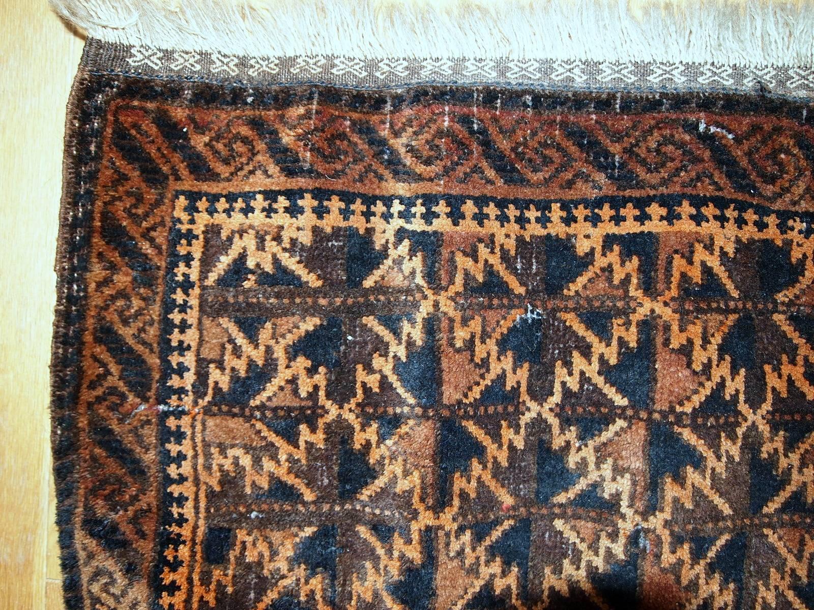 Antique handmade Afghan Baluch bag face. The rug has geometric repeating pattern in the diamond shapes. The main colors on this rug are orange, different shades of brown. Beautiful artistic border surrounding the rug. The rug is in original