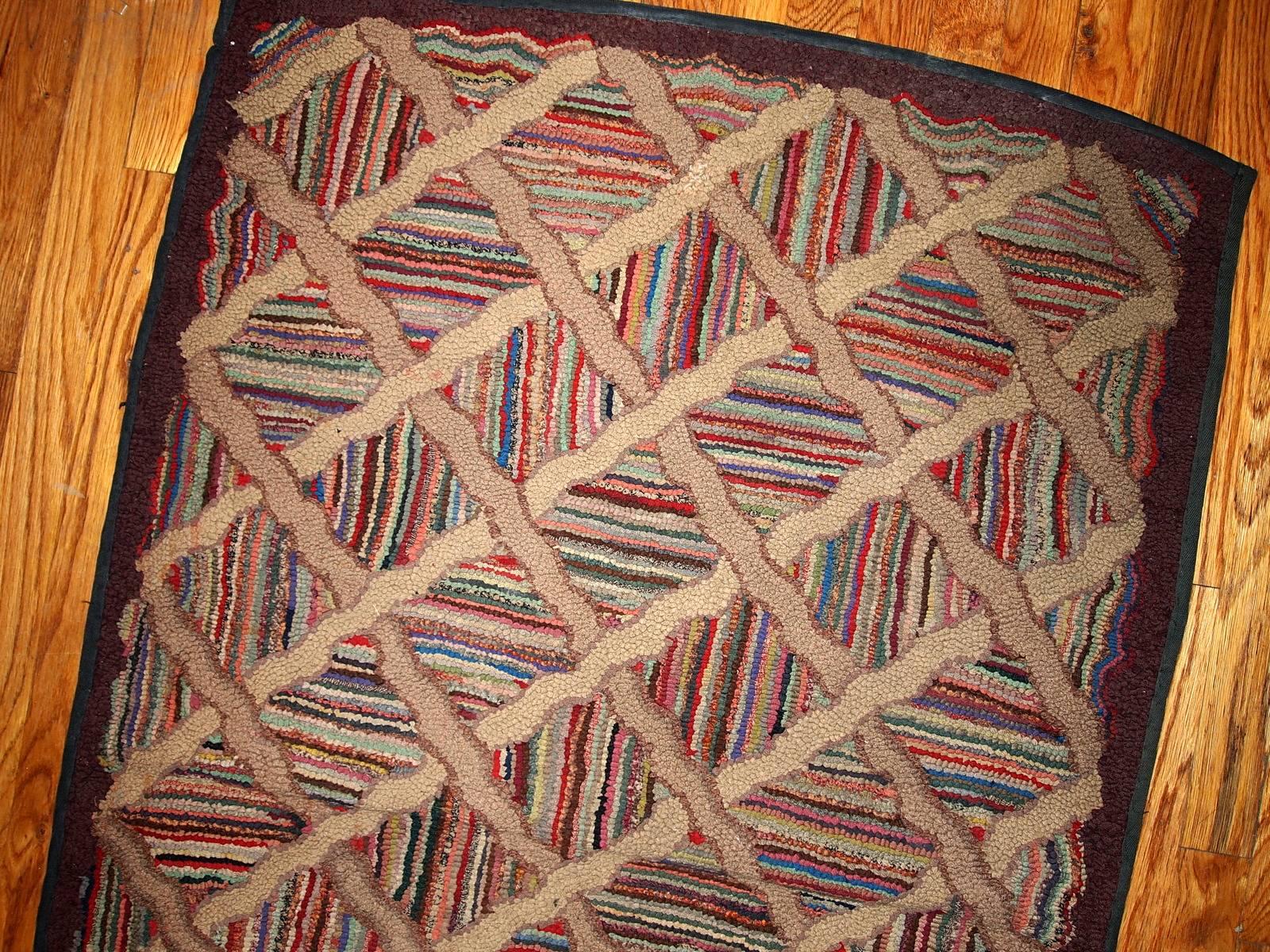 Antique hand-hooked American runner in original good condition. This rug was made in the end of 19th century in geometric design, which was not very usual for that time. The rug has colorful stripes all over it and larger diamond shaped mosaic
