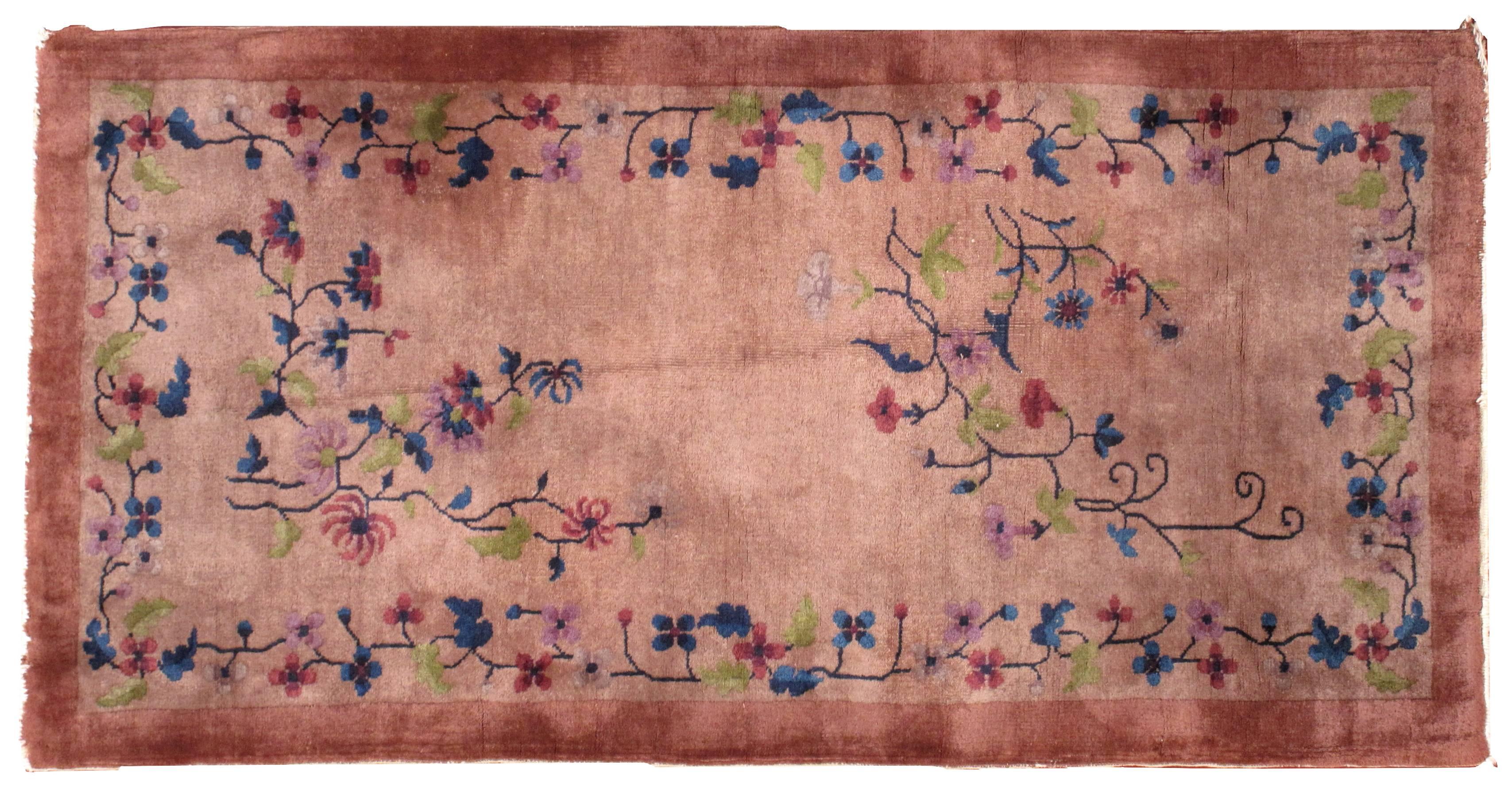 Chinesischer Art-Déco-Teppich im Originalzustand. Dieser Teppich wurde in hellem Burgunderrot für das Feld und dunklerem Burgunderrot für die Bordüre gefertigt. Der Teppich ist mit einem floralen Muster versehen, das in unregelmäßigen Abständen über