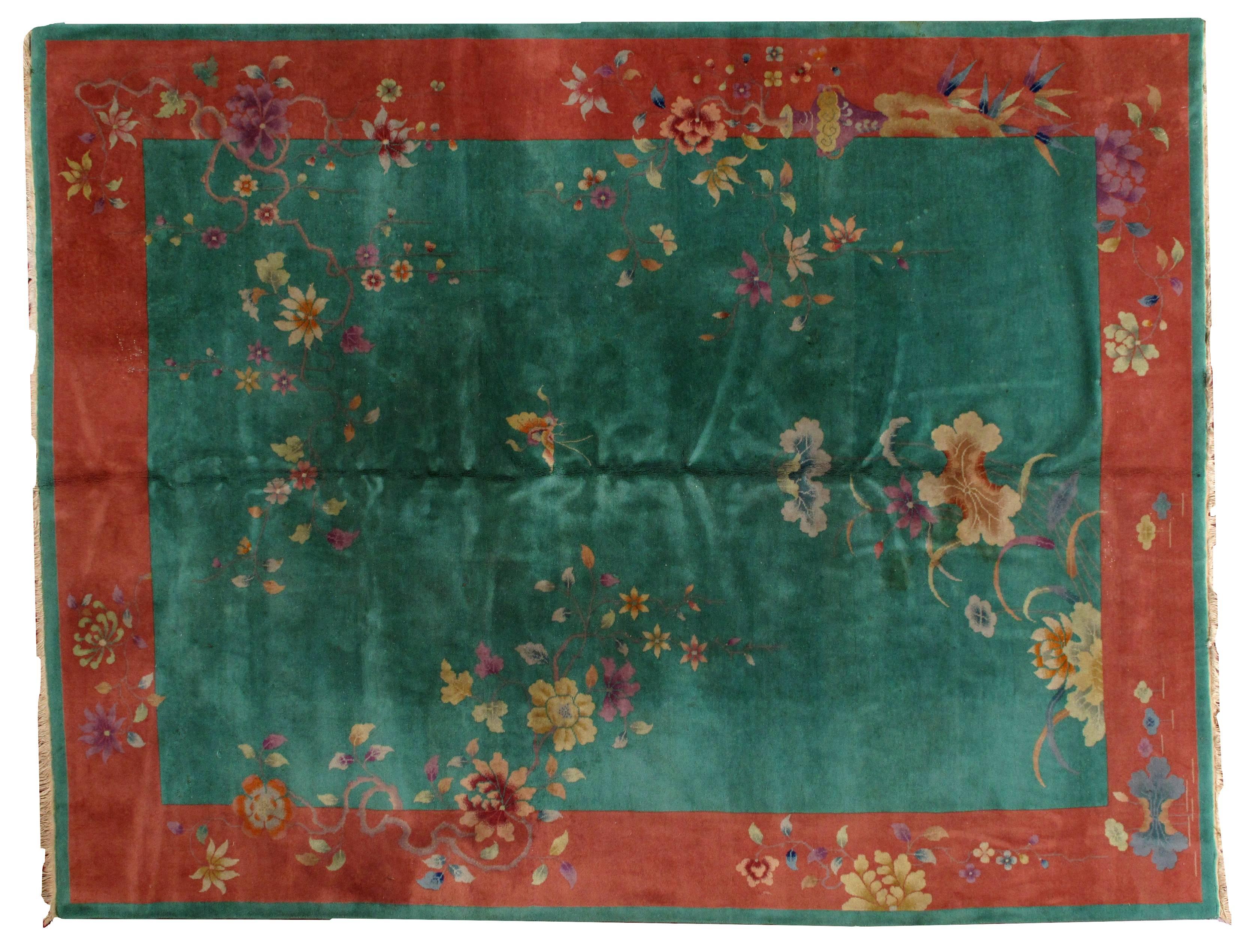 Antique Art Deco Chinese rug in original condition. The rug has beautiful deep green color of the field and orange border. Some classic floral design with the large flowers and vase decorating the rug. The rug is in original good condition.
 