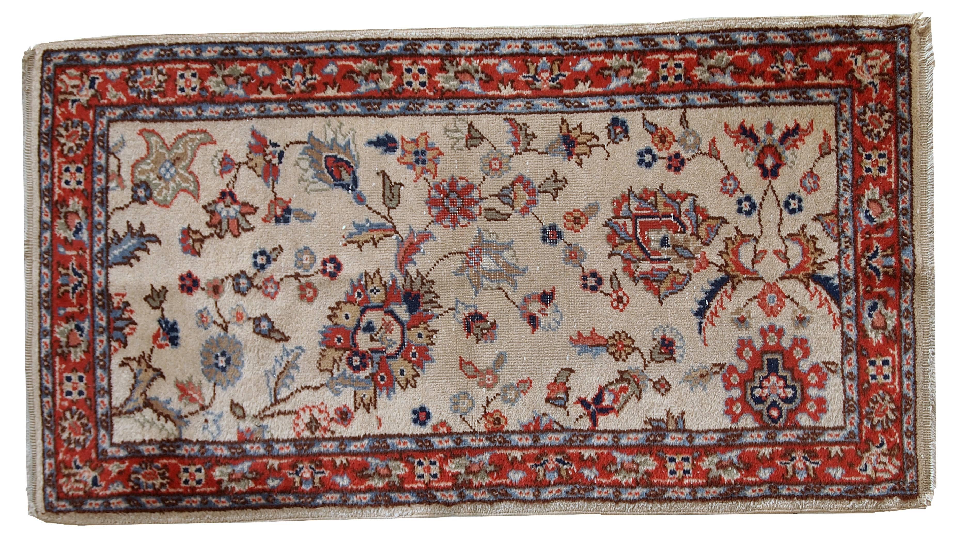 Vintage handmade Pakistani Lahore rug. This Pakistani rug has beige open field with floral accent on it in red, navy blue and olive green shades. The red border is also decorated with floral design. The rug is in original condition, it has some low