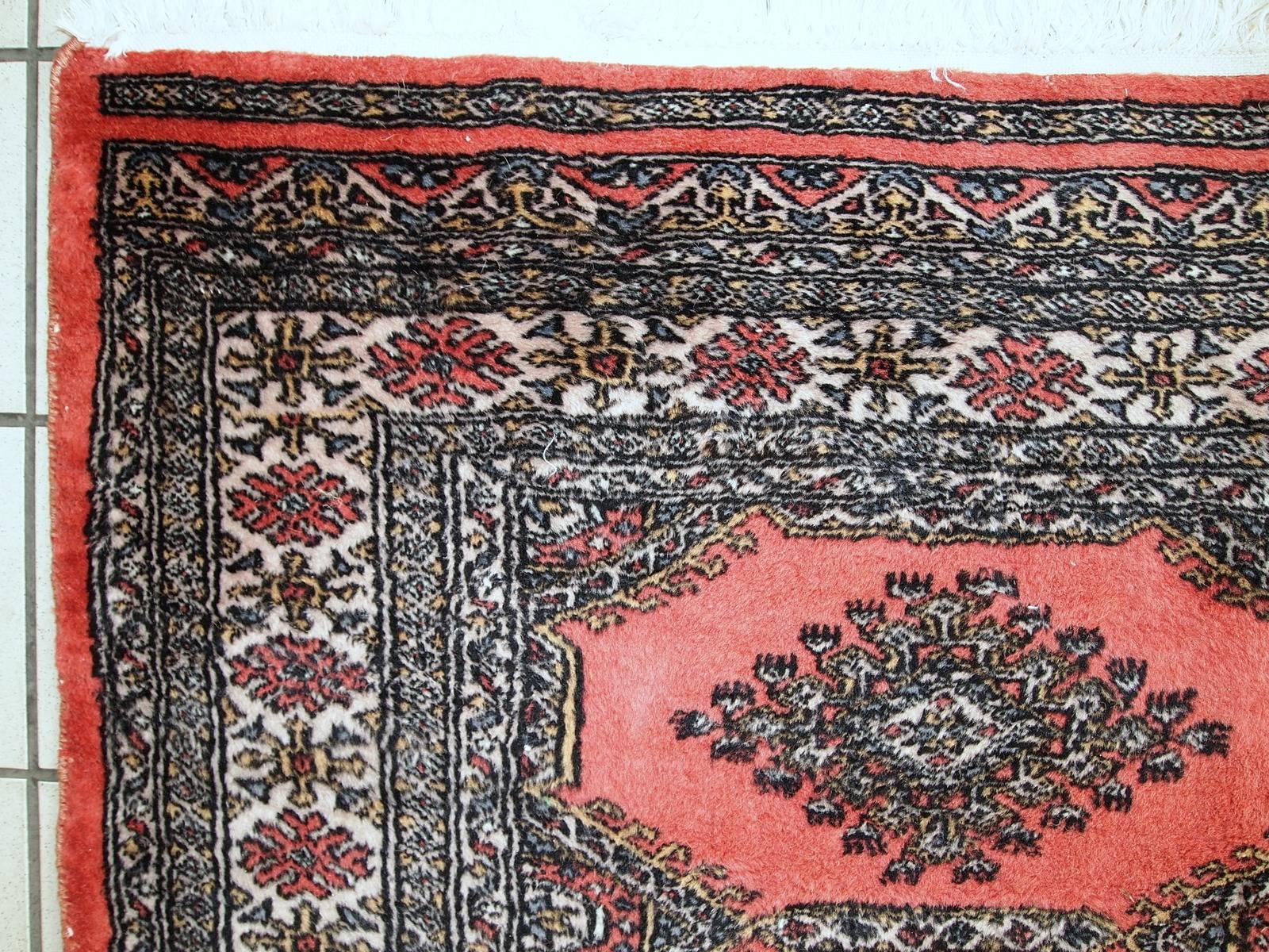 Vintage handmade Uzbek Bukhara rug in original condition. The rug made in classic Bukhara design. Peach filed decorated with five diamond shaped medallions. The border is in colourful shades and has very busy design. The rug is in original good