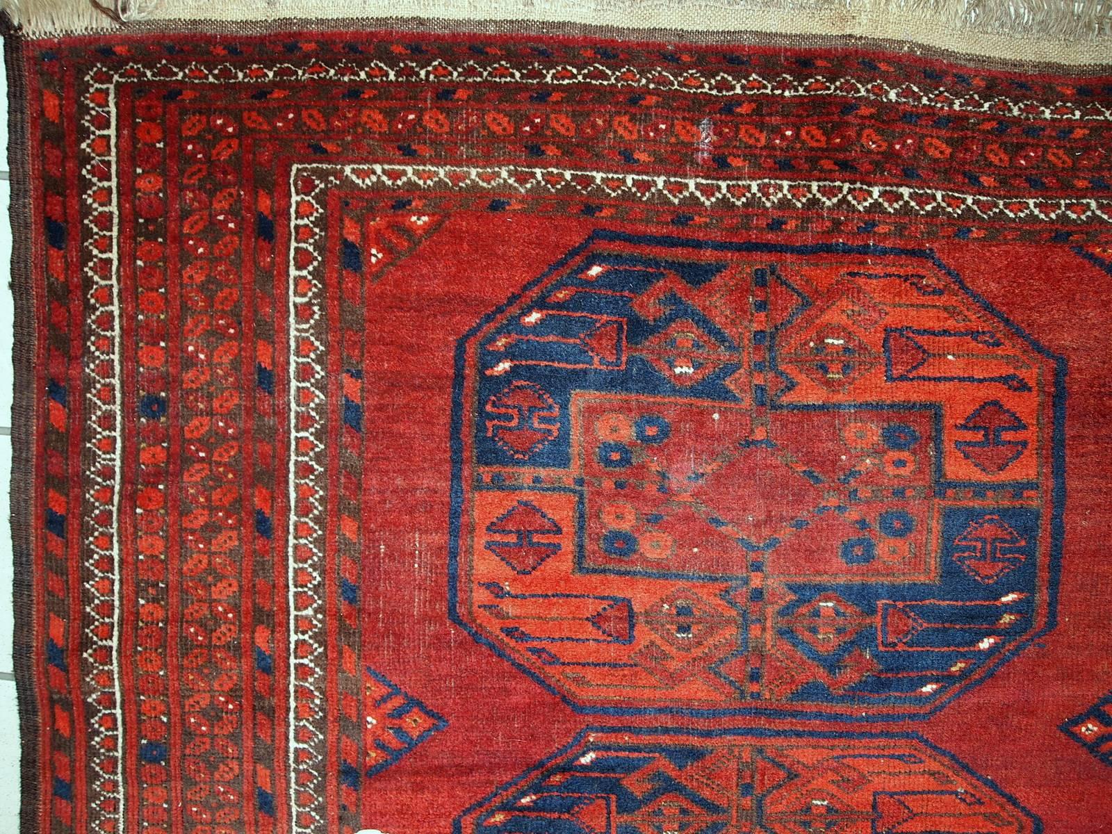 Antique Afghan Ersari rug in original good condition. The colors on this rug are typical Ersari shades: navy blue and bright red with some brown accents. The background has multiply large medallions along the lengths of the rug. Beautiful tribal