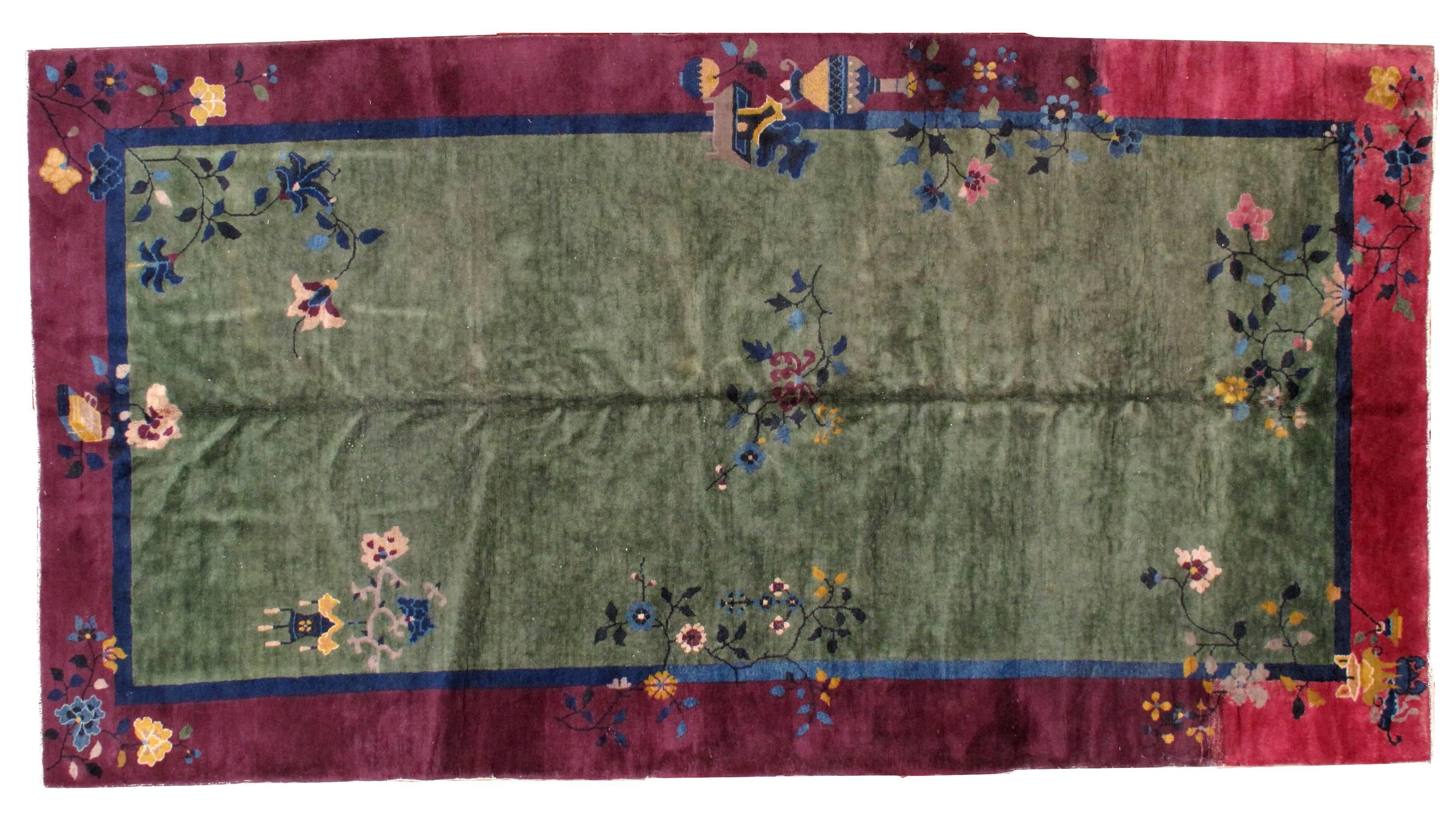 Antique Art Deco Chinese rug in original condition. The rug has green background color and border in burgundy border for the most of the part, on one side the border changes to a fuchsia shade. Very unusual size. The condition is original good, has