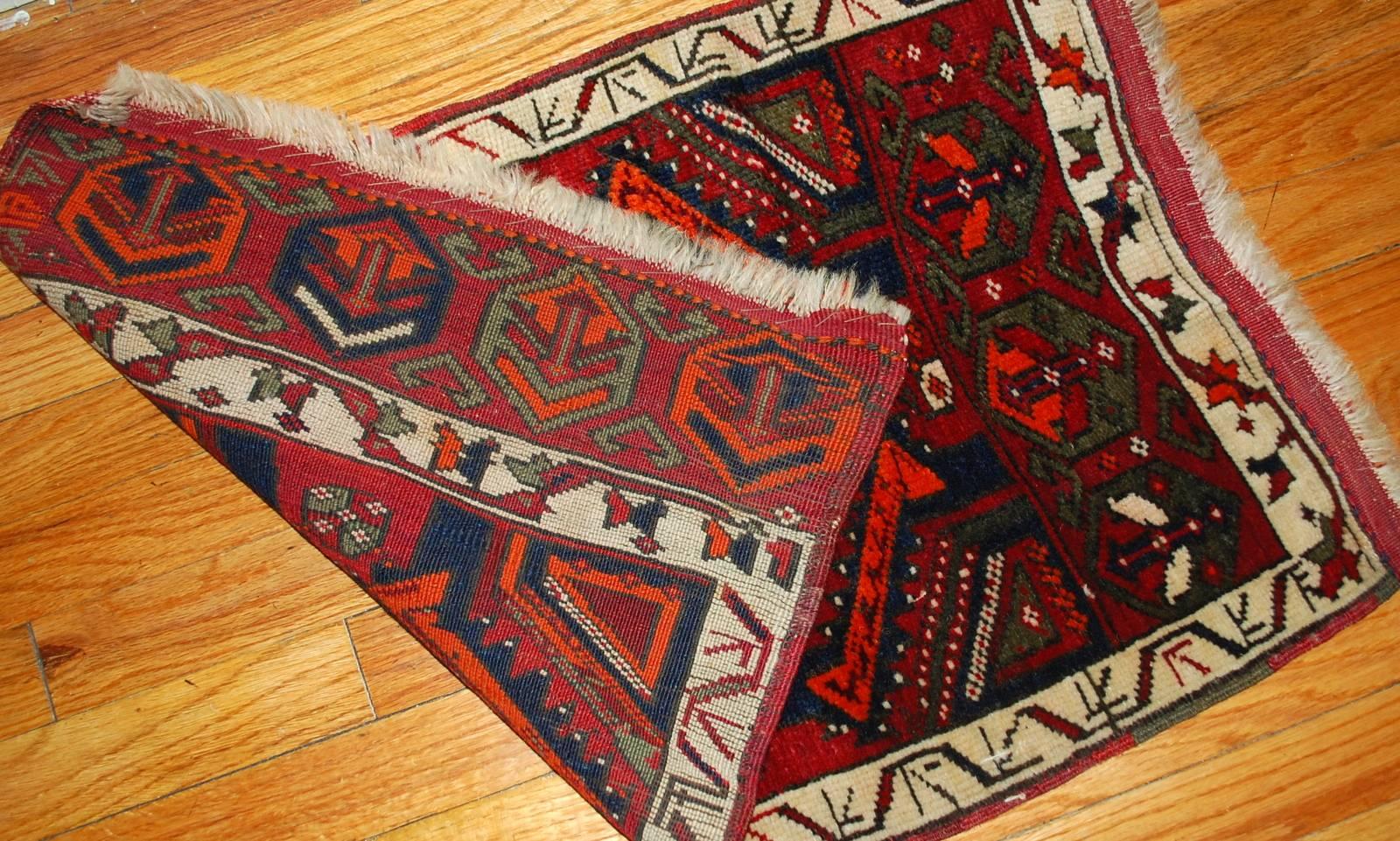 Antique Turkish Yastik rug in original condition. The rug made in combination of bright and dark colours. This Yastik has very busy tribal design. The deep red field decorated with ornaments in bright orange ( natural, not chemical) and bright blue