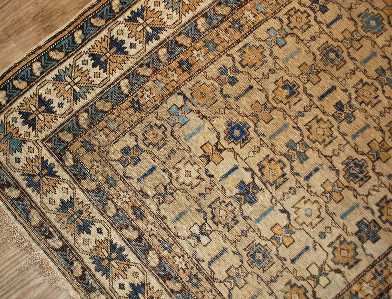 Antique handmade Caucasian Shirvan rug in original condition. The rug is in light shades of brown, beige and azure colors. It has open field with busy tribal pattern and beautiful beige border with similar pattern on it. The condition is good, it