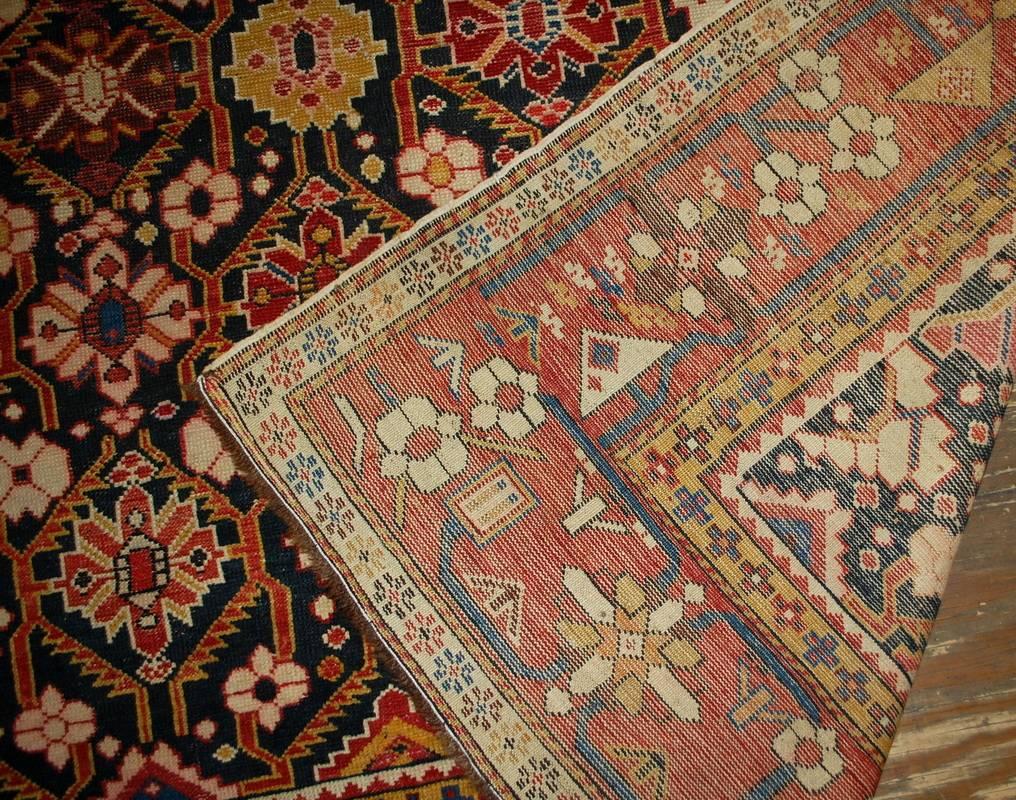 Antique handmade Russian Karabagh rug in great condition. The rug has unusual black background with repeating tribal design on it. The combination of floral and geometric ornaments makes it very charming. The red border with similar design