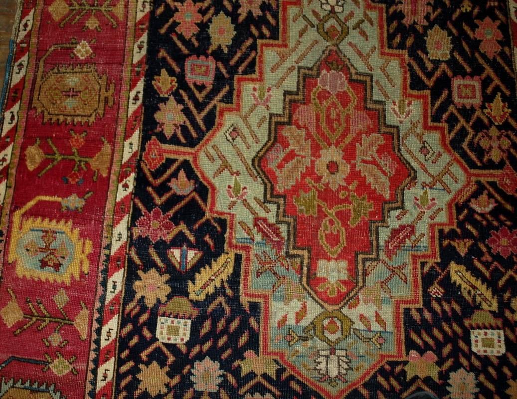 Antique handmade Russian Karabagh rug in great condition. The rug has black background with large charming diamond shaped design. Tribal ornaments are decorating the field randomly. Beautiful crimson border surrounding this rug. This rug has been