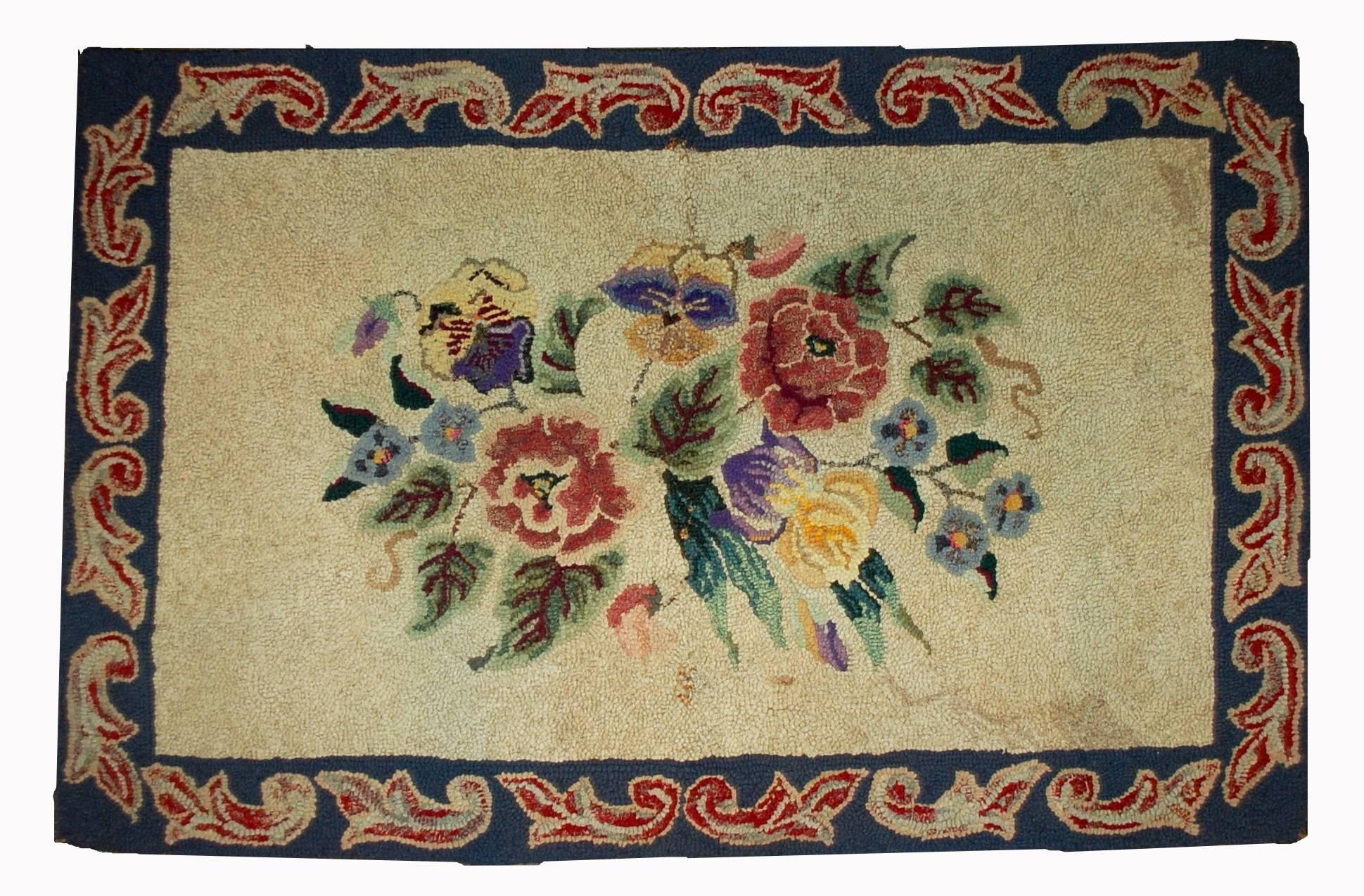 Handmade antique floral American hooked rug in original good condition. The rug made in classical floral design: bouquet of lowers in the middle of beige field. Very nice borer in blue shade with re decorations on it. The rug is in good