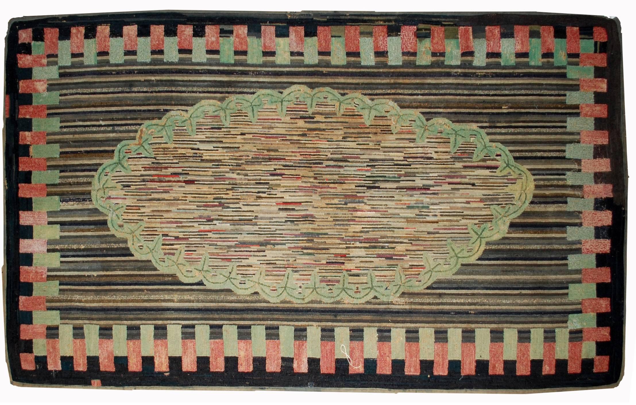 Handmade antique American hooked rug in good condition. The rug has been made in geometric design with colourful striped all over the rug and large oval medallion covered even with thinner colourful stripes as well. Geometric border in black, green