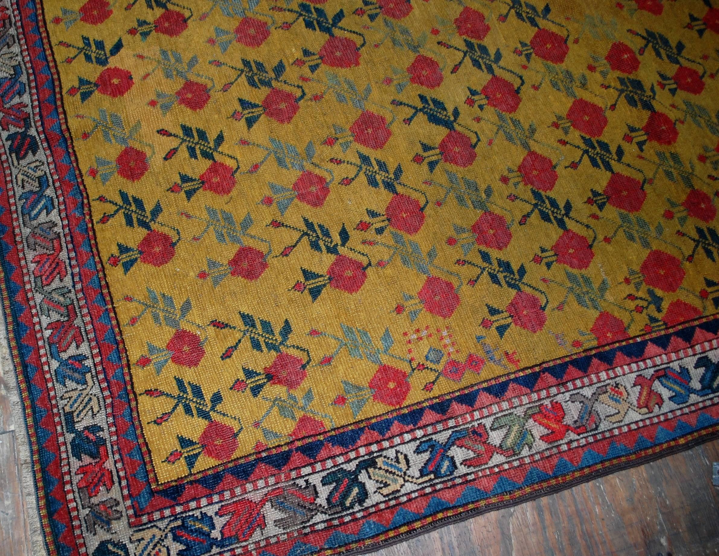 Antique handmade Russian Karabagh rug in great condition. The rug made in charming floral design on the all-over yellow background. The beautiful white border with national ornaments surrounding the central area. The rug could bring the shines and