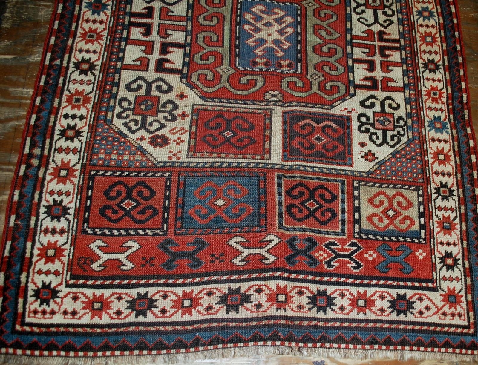 Antique handmade Russian Karabagh rug in great condition. The rug has been made in geometric design mixed with tribal. Very interesting two large medallions in the middle. White border decorated in tribal design as well. The rug has been restored