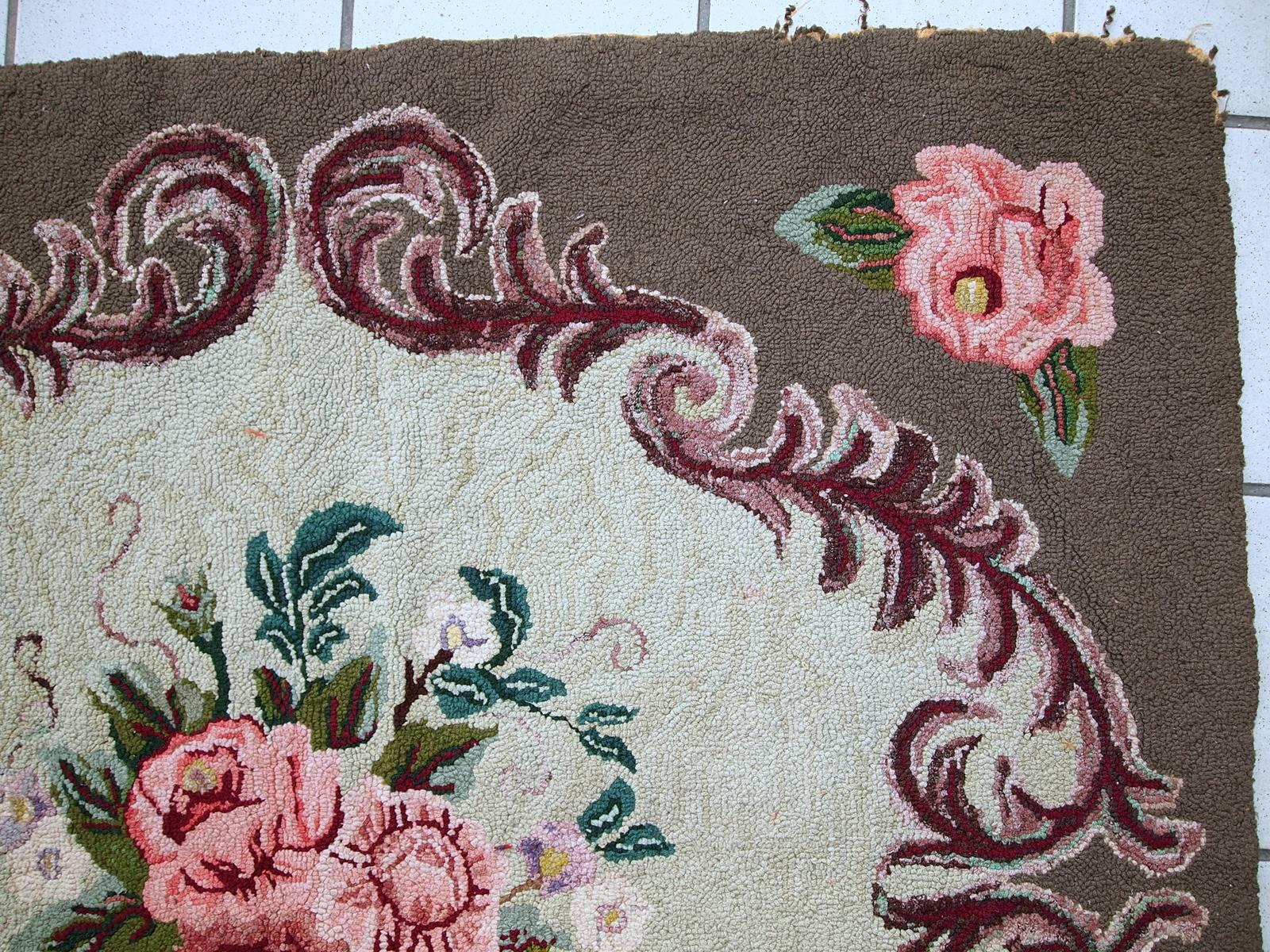 Antique American squarish hooked rug in good condition. The rug has squarish shape and made in very light shade of green for the background with the brown border around. It has been made in Victorian style. Large bouquet of flowers in the centre.