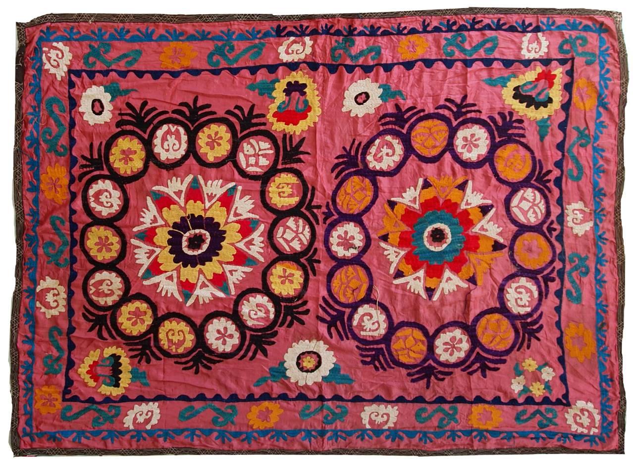 Vintage Uzbek Suzani embroidery in original good condition, except very little holes on the field. The rug made in cotton with woollen embroidery. Pink shade and colorful accents are in green, yellow, orange and black. This embroidery will be