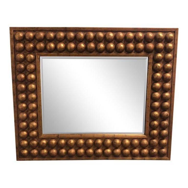 A stunning vintage wall mirror. This wood framed beauty has a double bubble row frame. The finish is a rustic gold with a distressed motif. The mirror itself is bevelled. It can be displayed vertical or horizontally. A great addition to any