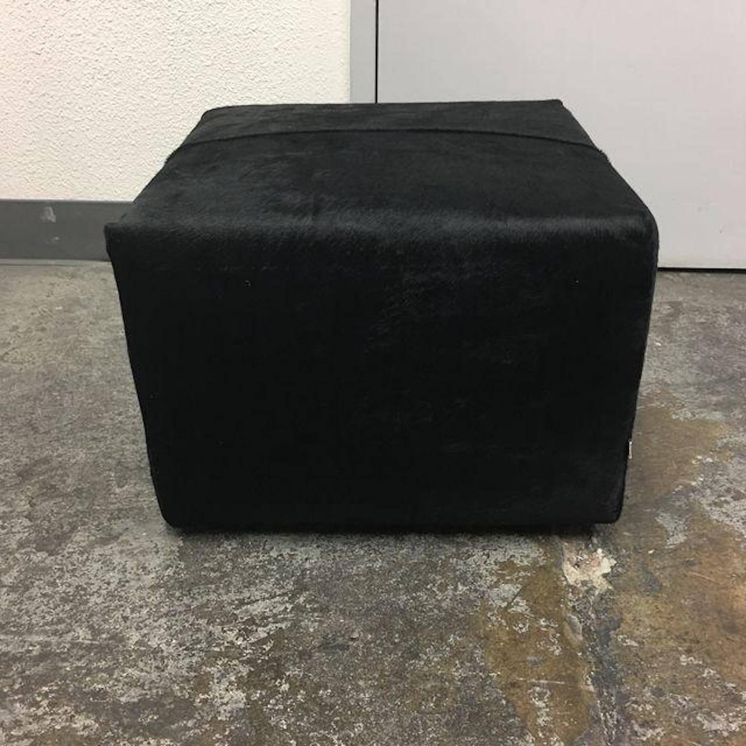 A P60 black leather cowhide ottoman for B&B Italia. Designed by Antonio Citterio. An ottoman with wheels, to be used everywhere as an additional seat or as a service element placed by tables, writing desks and shelves. The upholstery is a black